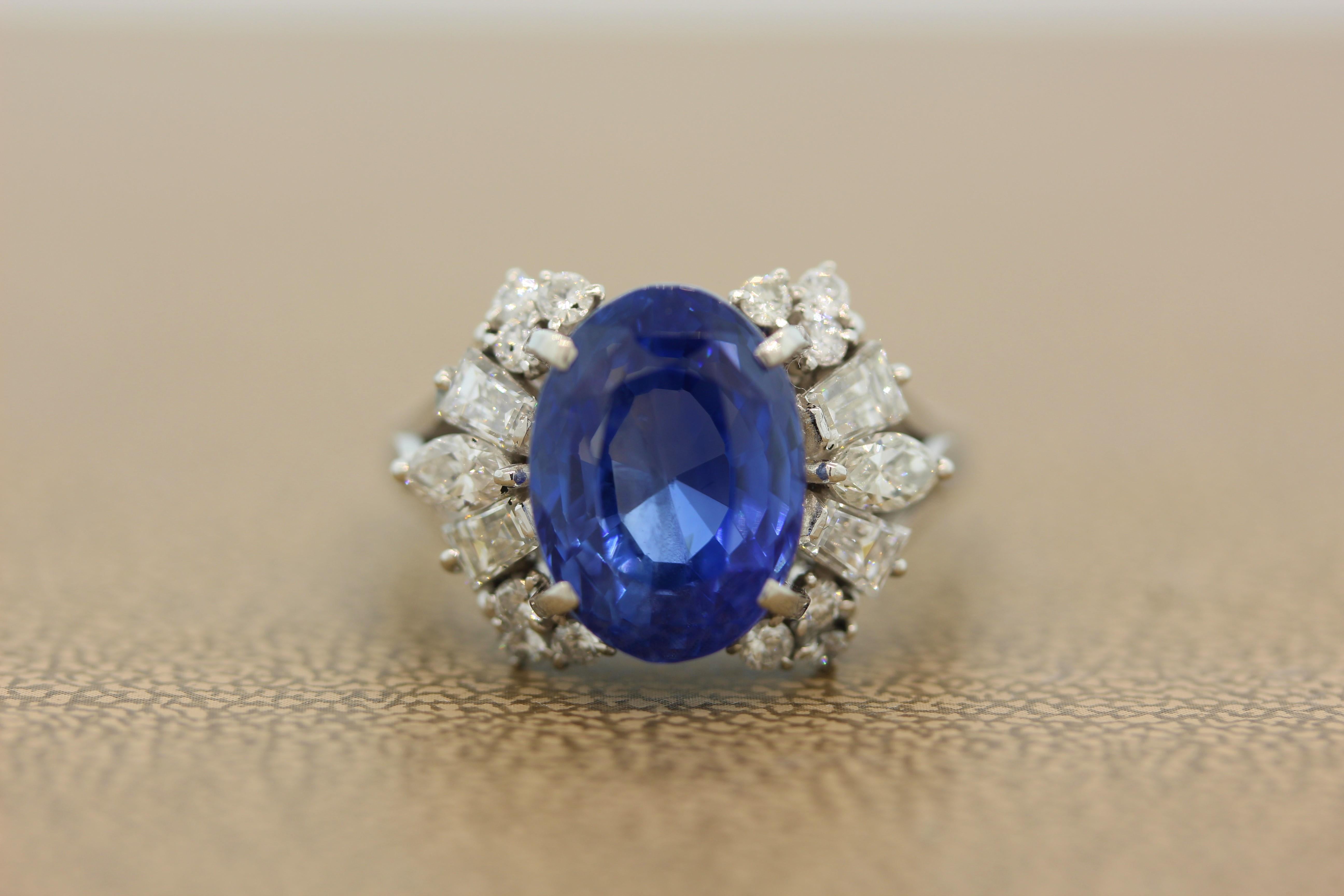 A GIA certified 8.93 carat blue sapphire without heat treatment. The oval cut sapphire has a luscious and even color through the stone, true gem quality. It is accented by a cluster of 1.07 carats of diamonds. Each side of the royal blue sapphire