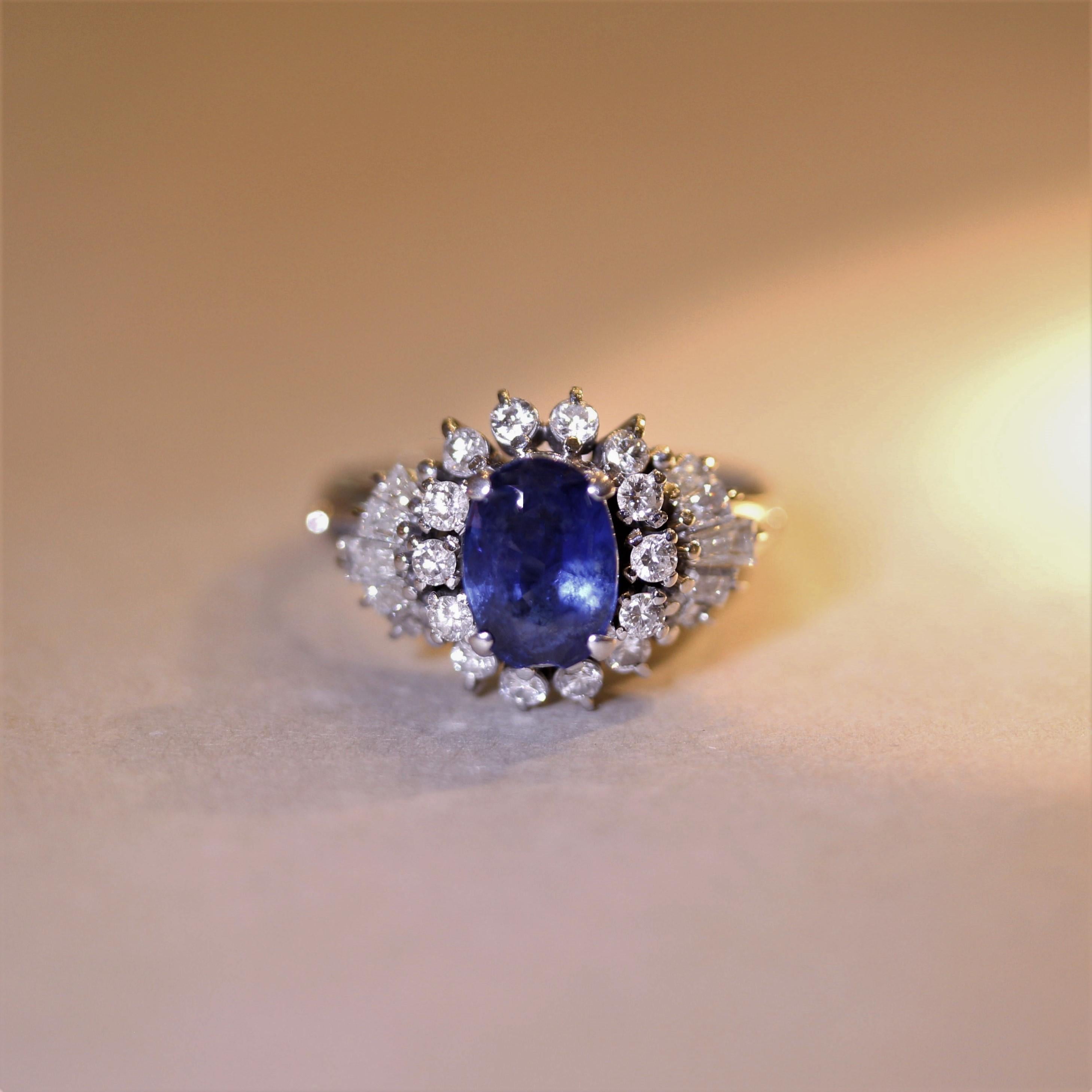 A chic and sexy sapphire ring! It features a beautiful 2.03 carat sapphire with an even vivid blue color and is shaped as an oval. It is accented by 0.88 carats of round brilliant-cut and baguette-cut diamonds which are set around the sapphire in a