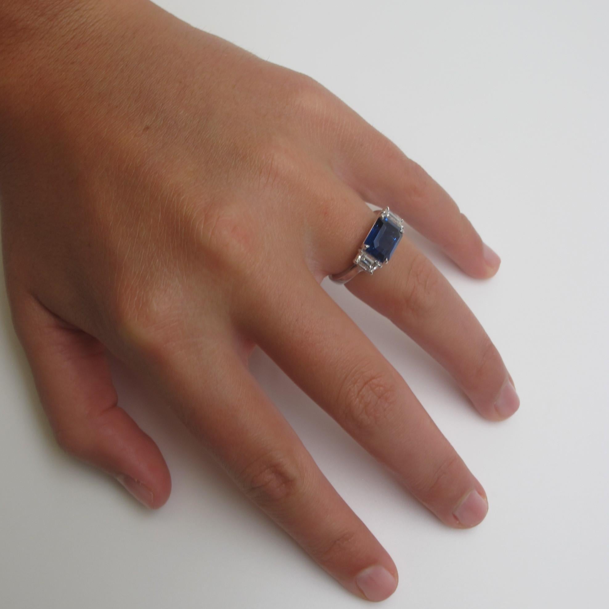 Something blue! Break the standard 'rules of engagement' with this 3 stone ring or wear it on your right hand. A beautiful heated Blue Sapphire (9.54x7.17mm/3.58cts) is flanked by fancy trapezoid shaped Diamonds (0.65cts tw/F-G color) in a ring that