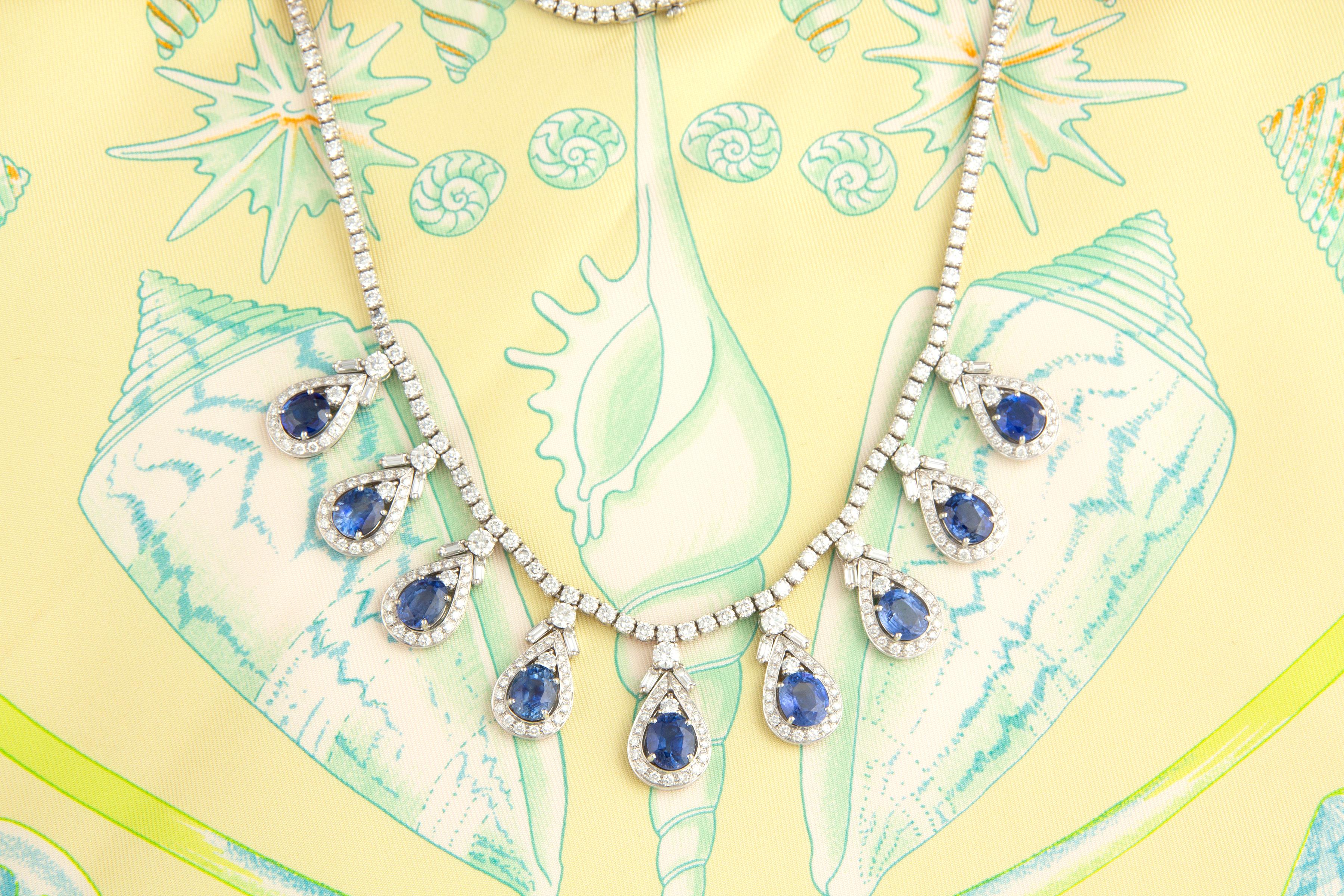 Le collier riviera saphir bleu et diamant présente une riviera merveilleusement articulée de 15,5 pouces de diamants ronds parfaitement calibrés et homogènes suspendant 9 diamants pesant chacun 0,20 carat. Le poids total des diamants du bijou est de