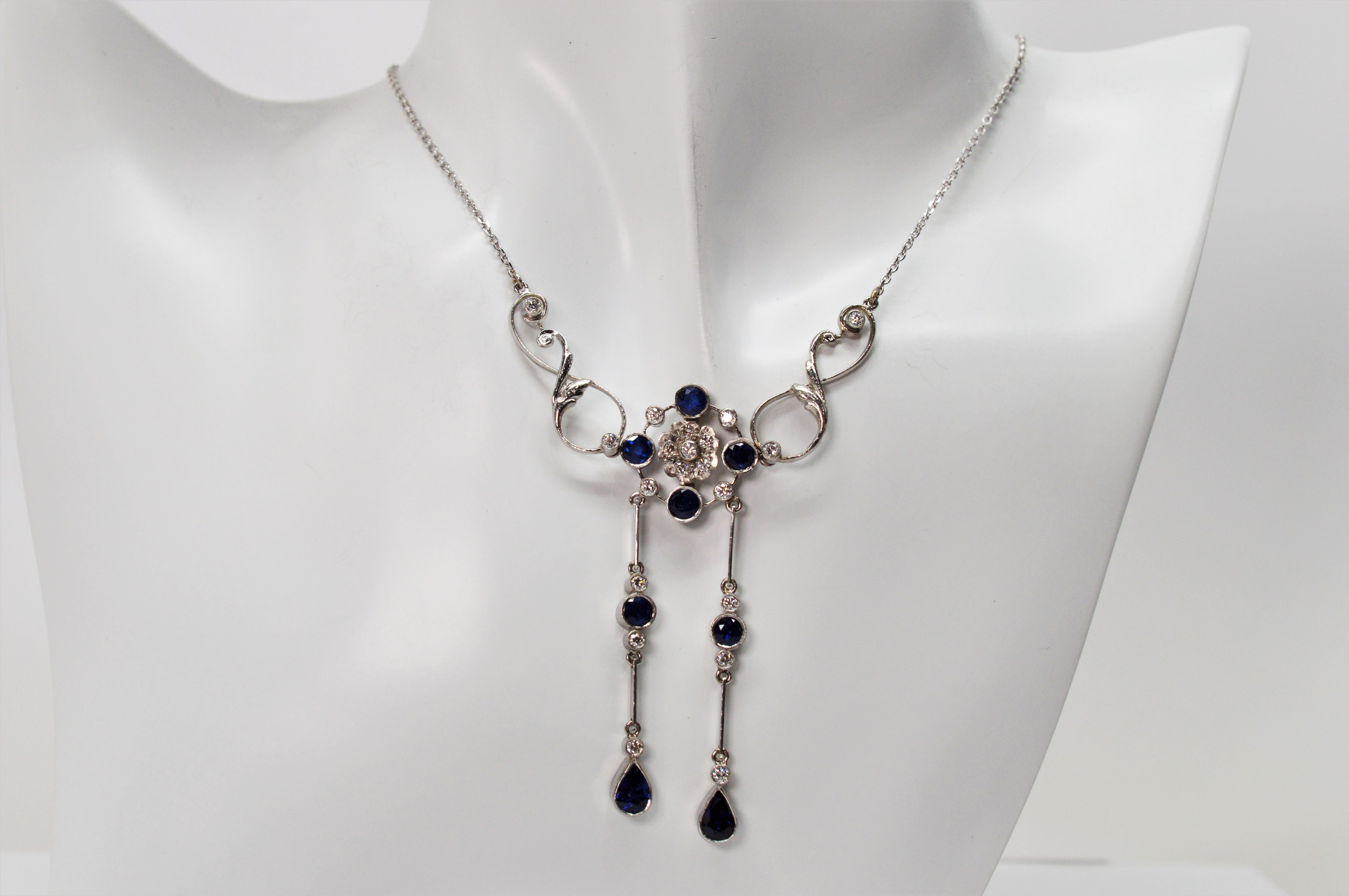 Turn heads with this spectacular blue sapphire and diamond drop pendant necklace in platinum. Perfect as a bridal piece or for that special occasion. The floral pendant centerpiece is crafted with vibrant round blue sapphires that are accent with