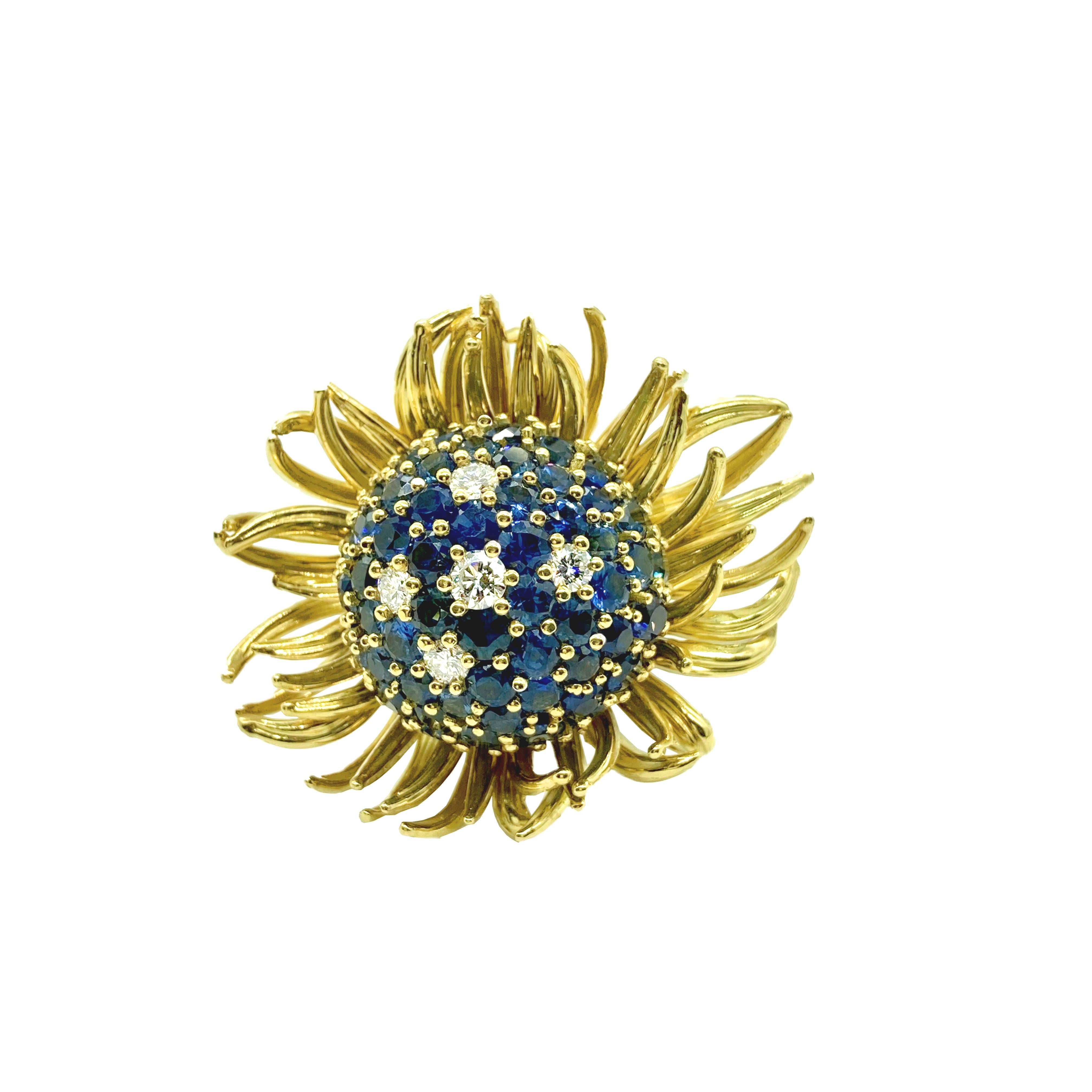 A fun floral cocktail ring featuring a large dome of blue sapphires and diamonds, surrounded by yellow gold petals. 