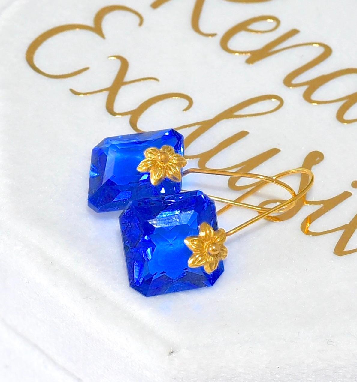 This unique pair of lab-created Blue Sapphire (12mm) earrings are like blue dreams! 18K Solid yellow Gold delicate details give the earrings a feminine look. Simple sophistication for your everyday accessories! The perfect gift for the holidays!