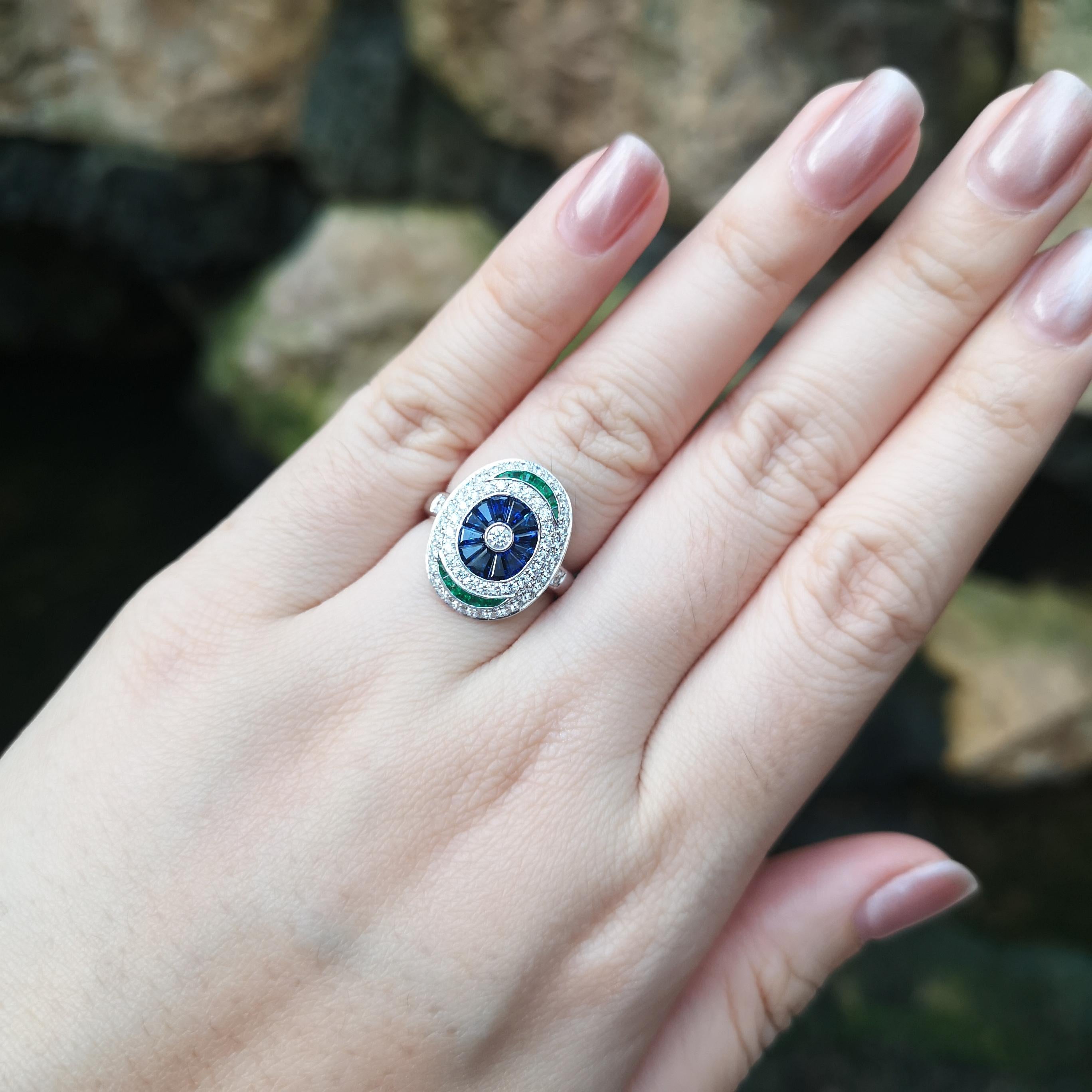 Ring mit blauem Saphir (1,15 Karat), Smaragd (0,64 Karat) und Diamant (0,65 Karat) in einer Fassung aus 18 Karat Weißgold

Breite:  1,4 cm 
Länge: 1.9 cm
Ringgröße: 54
Gesamtgewicht: 5.82 Gramm

