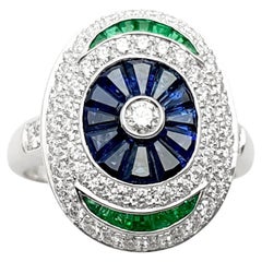 Anello con zaffiro blu, smeraldo e diamante incastonati in oro bianco 18 carati