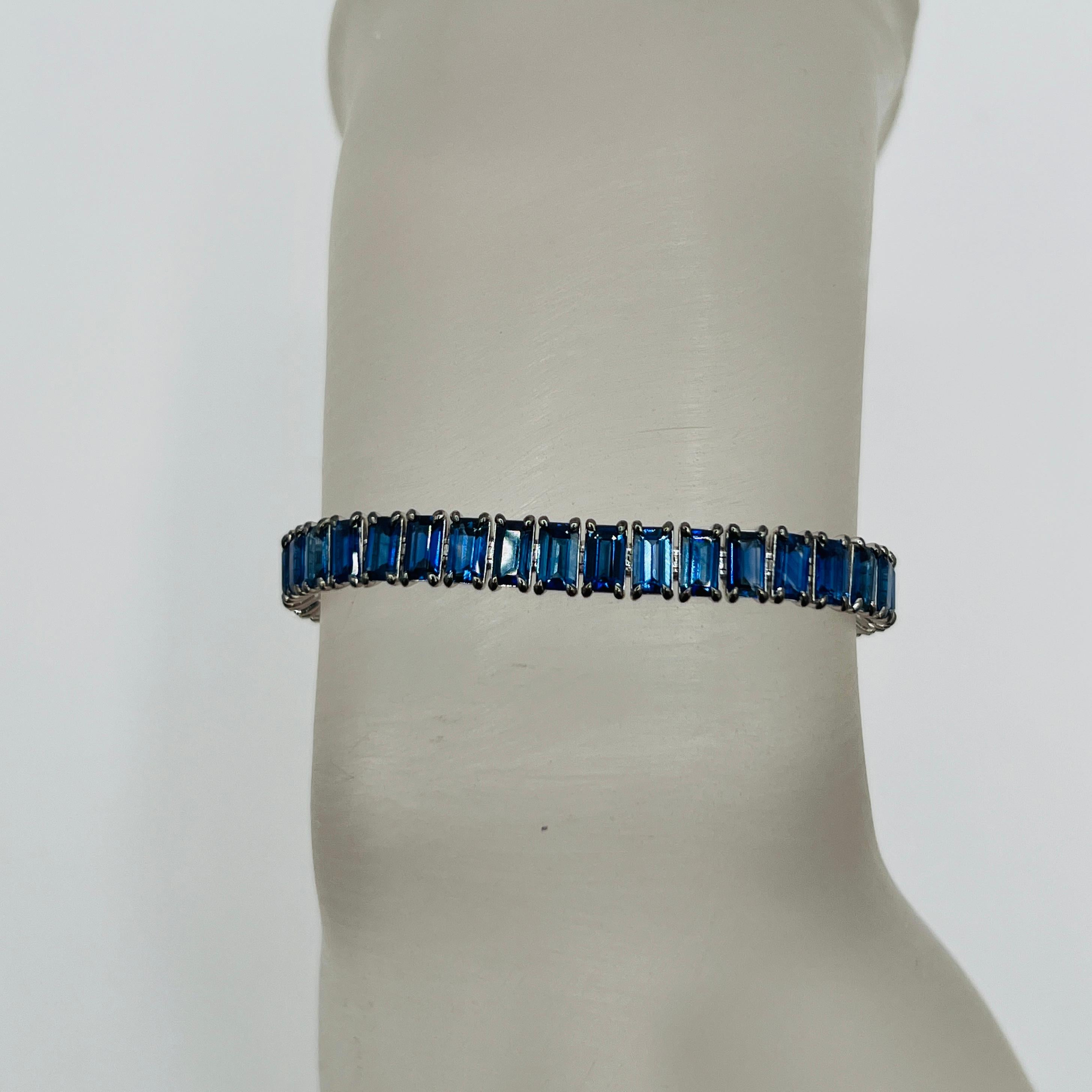 Magnifique bracelet de tennis de 14,31 ct. de saphir bleu taille émeraude.  Total de 49 pierres.  Fabriqué à la main en or blanc 18 carats.  La longueur est de 6,75