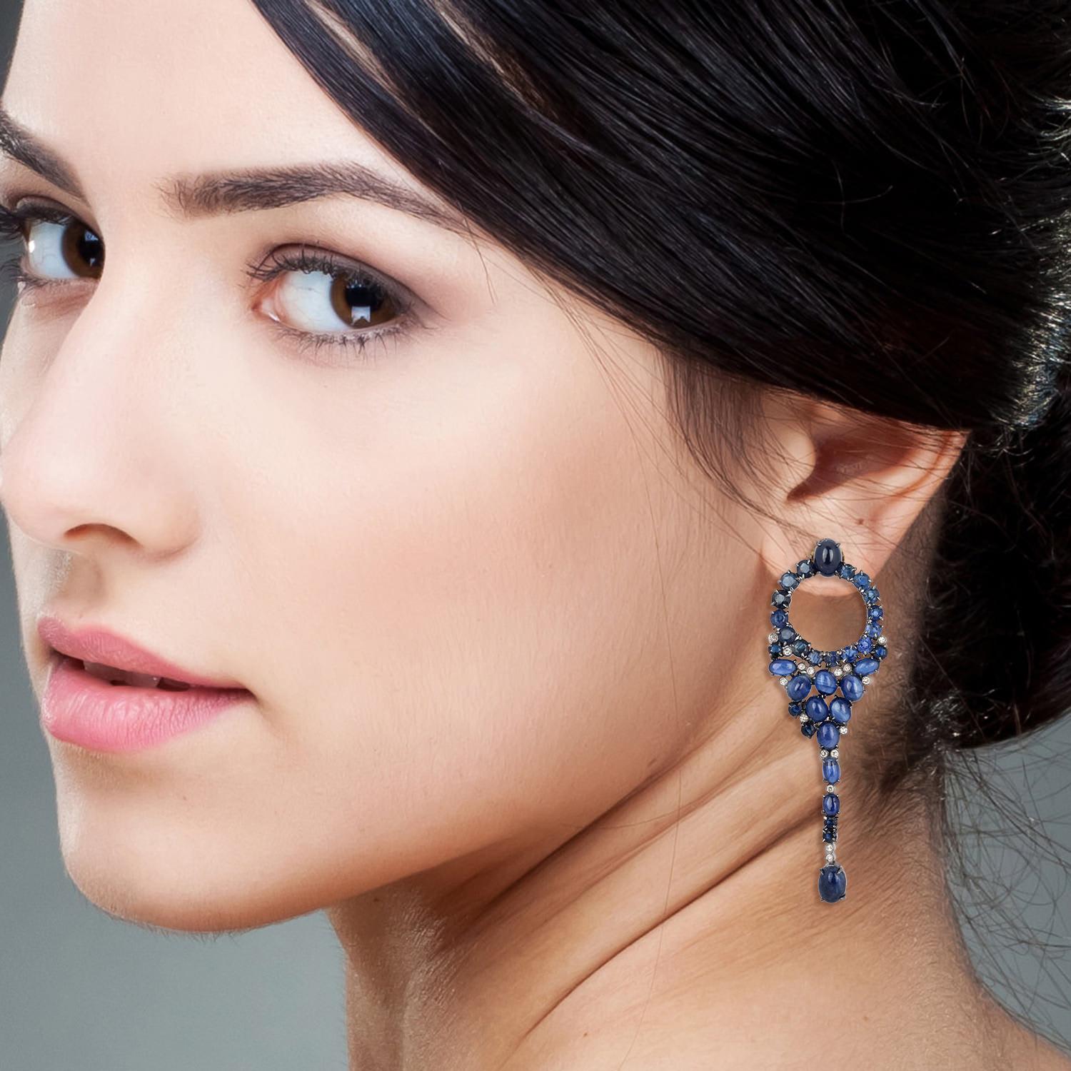 Cast in 18-karat gold & sterling silver, these stunning drop earrings are set with 20.53 carats blue sapphire and .18 carats of sparkling diamonds. 

FOLLOW  MEGHNA JEWELS storefront to view the latest collection & exclusive pieces.  Meghna Jewels