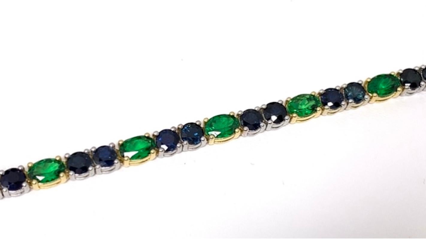 This gorgeous tennis bracelet features vivid deep blue sapphires paired with sparkling green tsavorite garnets! The richly colored blue sapphires have been set in bright, 18k white gold, while the vivid green tsavorites have been set in sparkling
