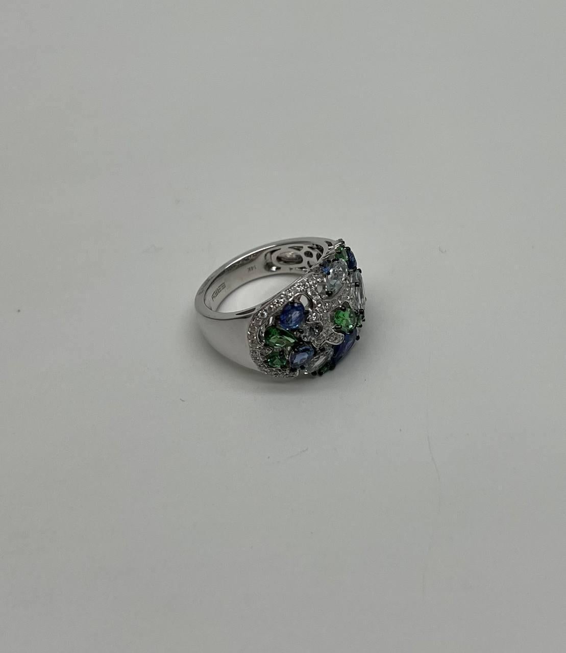 A striking ring featuring 3.24 carats of blue sapphires & green Tsavorites , showcasing a deep and captivating blue color. The ring is adorned with green tsavorites and white diamonds, creating a vibrant and elegant contrast. Crafted in 14K white