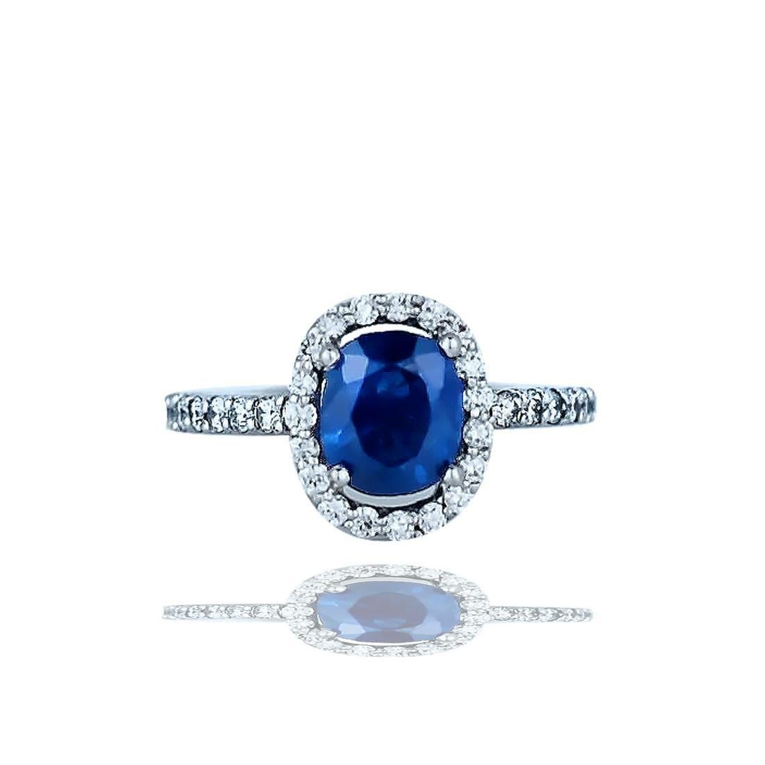 Halo, Sapphire and Diamond Ring weighting 2.82 total carat weight in this stunning solitaire setting. 

The center blue sapphire is oval shaped measuring 7.71-6.70 x 4.56 mm with a estimated weight of 1.97 carats. The blue color is a beautiful with