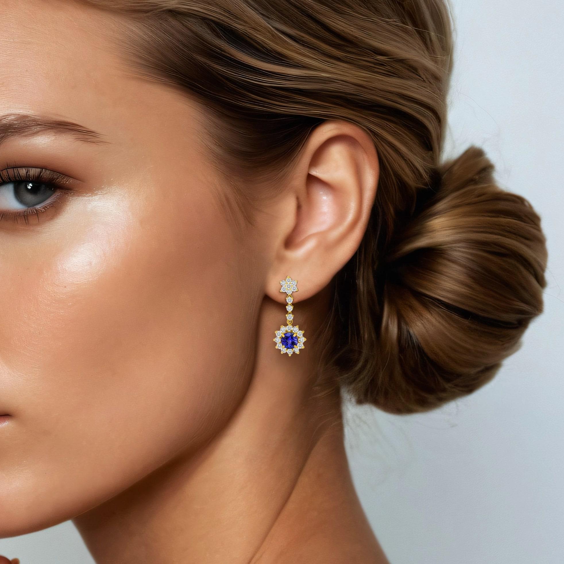 These dazzling Halo Drop Earrings feature a pair of Round Cut Blue Sapphire Gemstone accompanied by small Round Cut Diamond side stones set in beautiful Halo Drop setting 14k Gold. Perfect as a gift for Anniversary, Birthday, Wedding, and/or