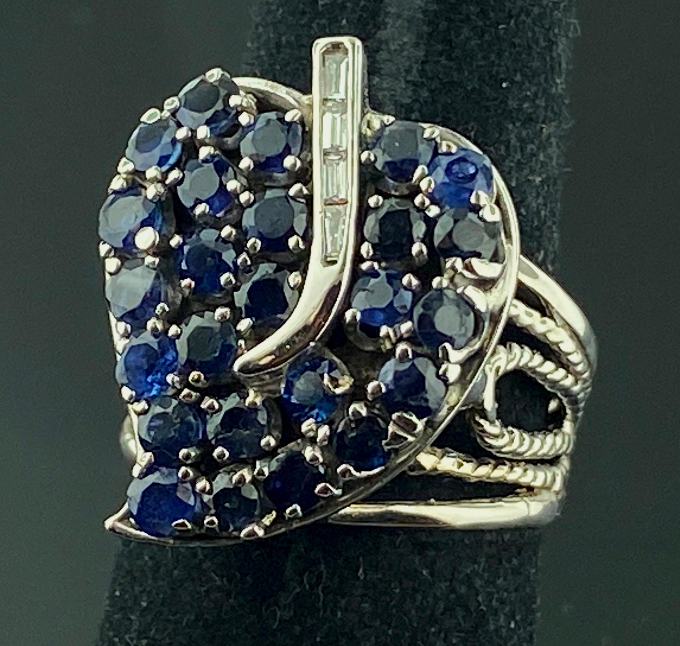 Set in 14 karat white gold are 25 round blue sapphires with a total weight of 2.25 carats, along with 4 baguette cut diamonds with a total diamond weight of 0.15.  Ring size is 6.5.
