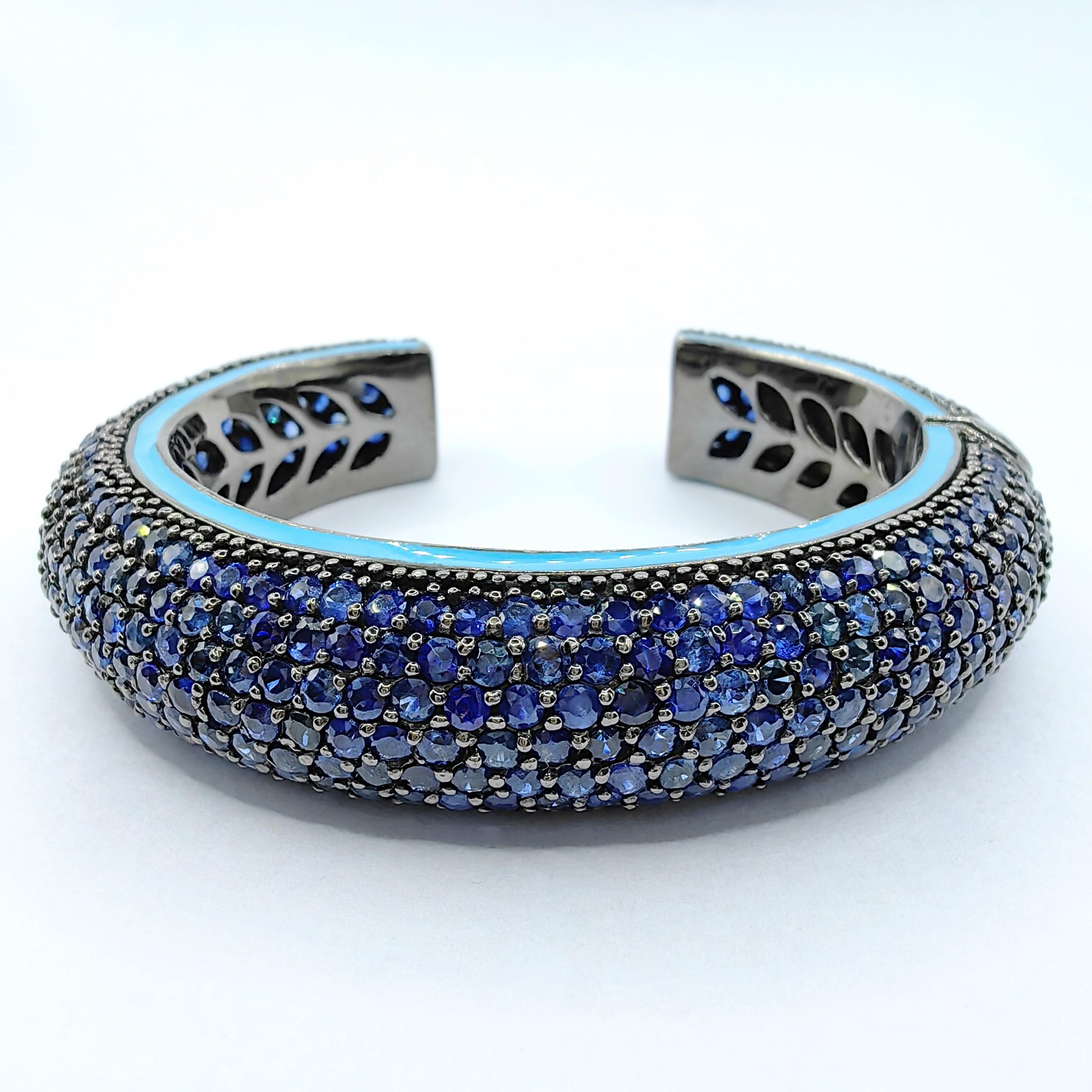 Ilumina tu estilo con el exquisito Brazalete con Esmalte Azul Zafiro Mediodía de Plata de Ley, una pieza que combina una audaz sofisticación con un toque de color vibrante. Este impresionante brazalete lleva incrustados innumerables zafiros azules