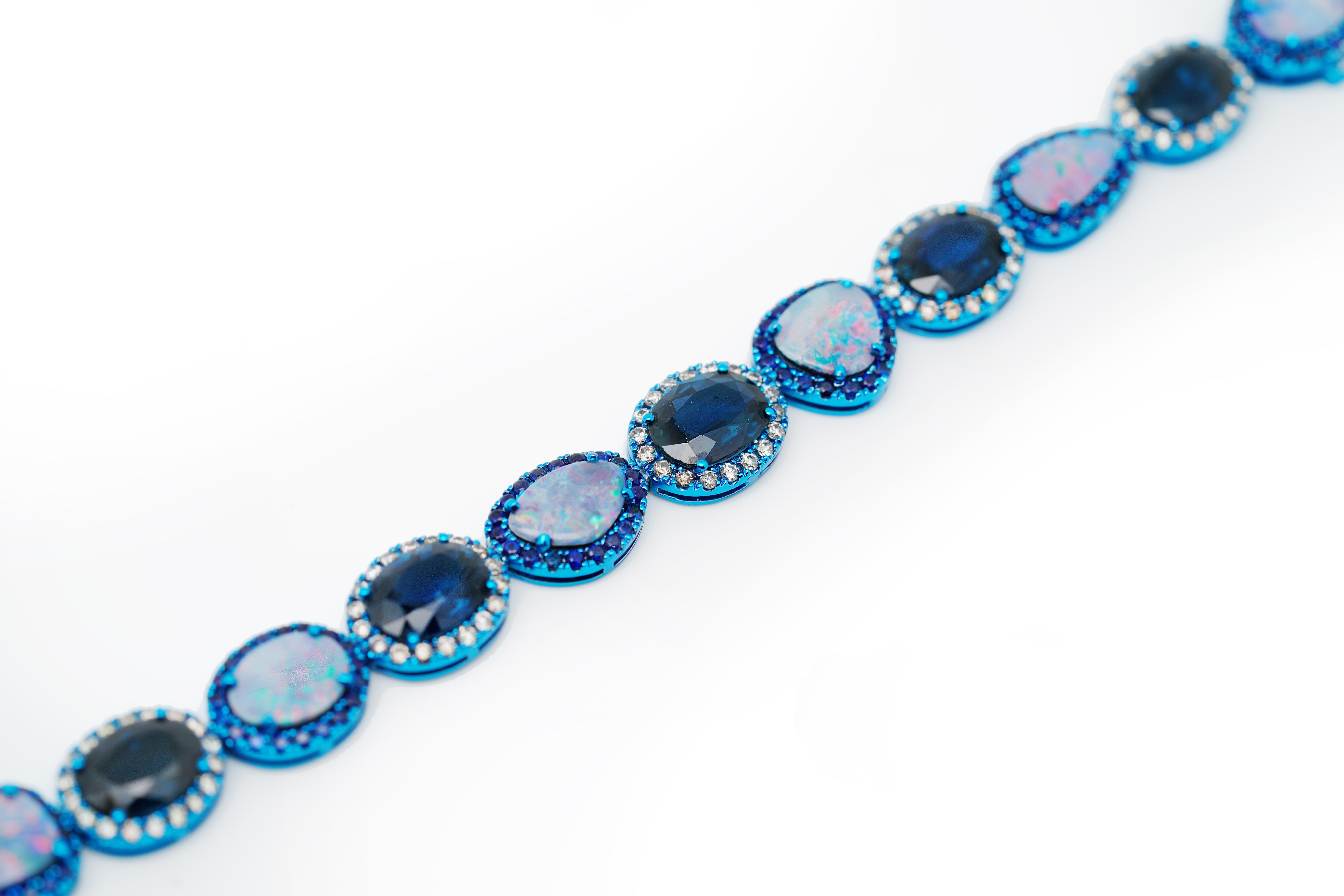 This unique and stylish bracelet features Natural Sri-lankan Blue Sapphires, Australian Boulder Opals and Diamonds, set on blue-color plated 18K White Gold. This bracelet is designed with the gemstones (Sapphire and Opal) in alternating arrangemnet,