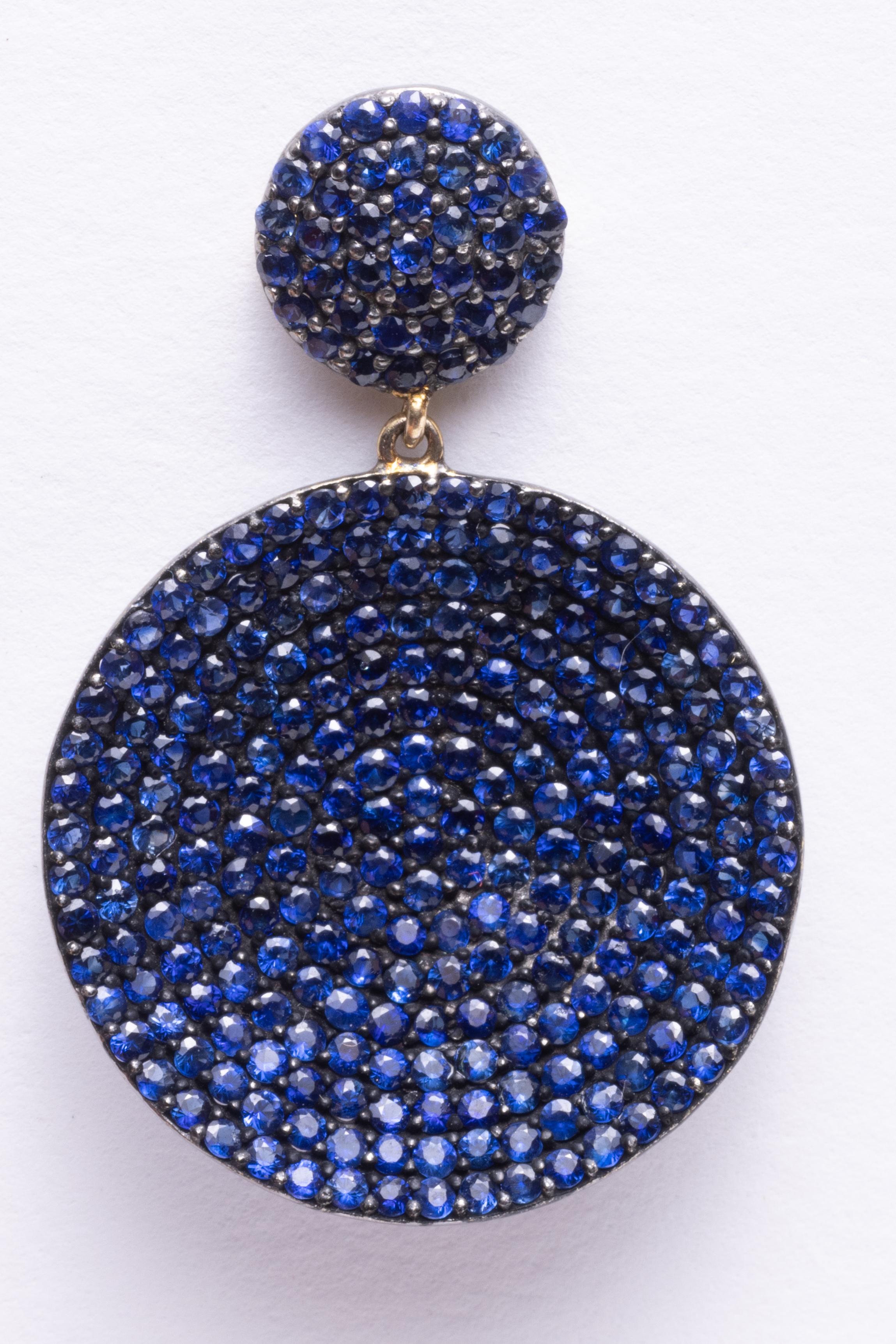 Fabulous round, brilliant cut blue sapphires in a pave` setting.  Set in an oxidized sterling silver and an 18K gold post for pierced ears.  Total weight of sapphires total 5.6 carats.