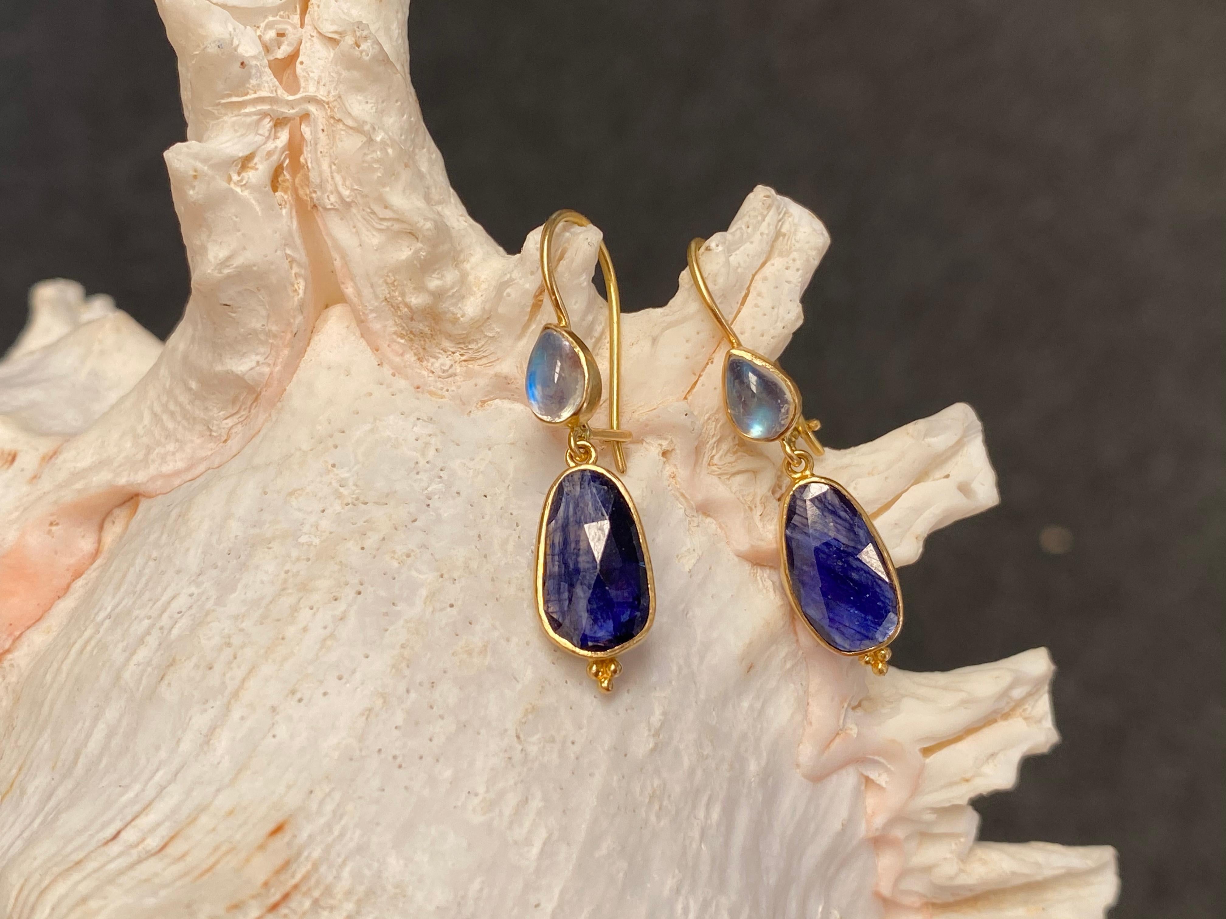 Irregular rose cut blue sapphires are suspended below pear shaped rainbow cabochons in this design. A simple display of complementary colors and contrasting shapes. Safety clasp wires. 7,8 carats total stone weight. 