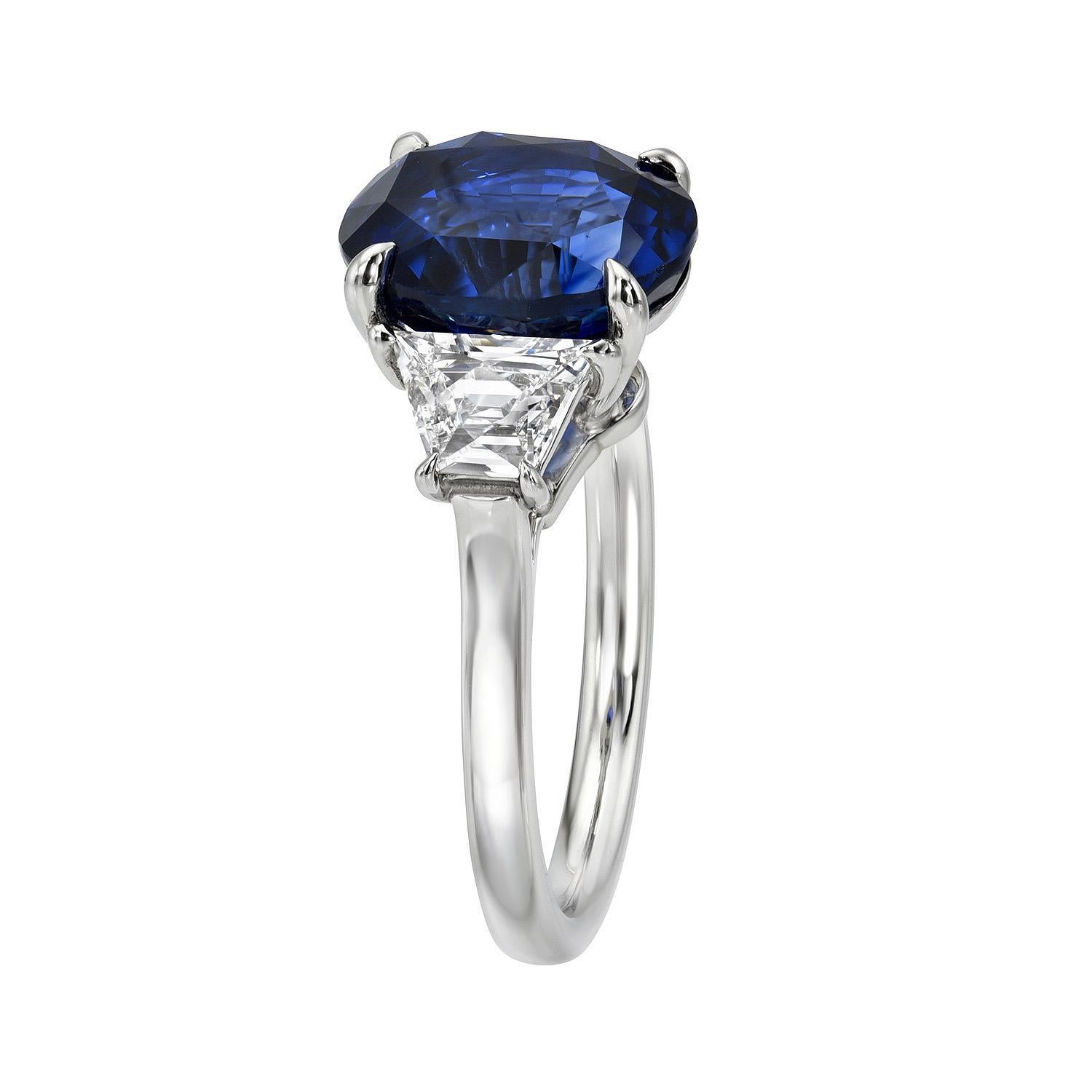 5.08 Carat Royal Blue Sapphire oval platinum three stone ring, flanked by a pair of 0.88 carat, E/VS French cut Trapezoid diamonds. 
Ring size 6. Resizing is complementary upon request.
The GIA gem report is attached to the image selection for your