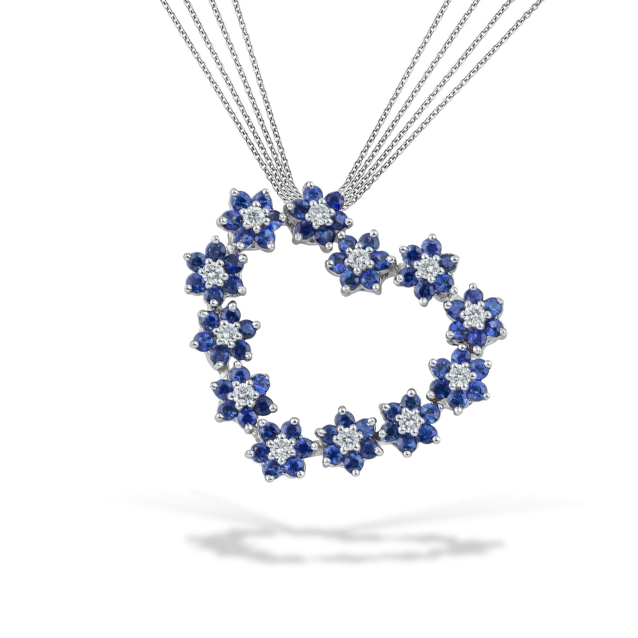 Herz-Anhänger-Halskette mit blauer Saphir-Rosette und Diamanten im Brillantschliff. Dieses romantische und leicht zu tragende blaue Herz wird mit einer Multikette (x4 diamantgeschliffene Roloketten) aus 18kt Weißgold geliefert. Diese Halskette