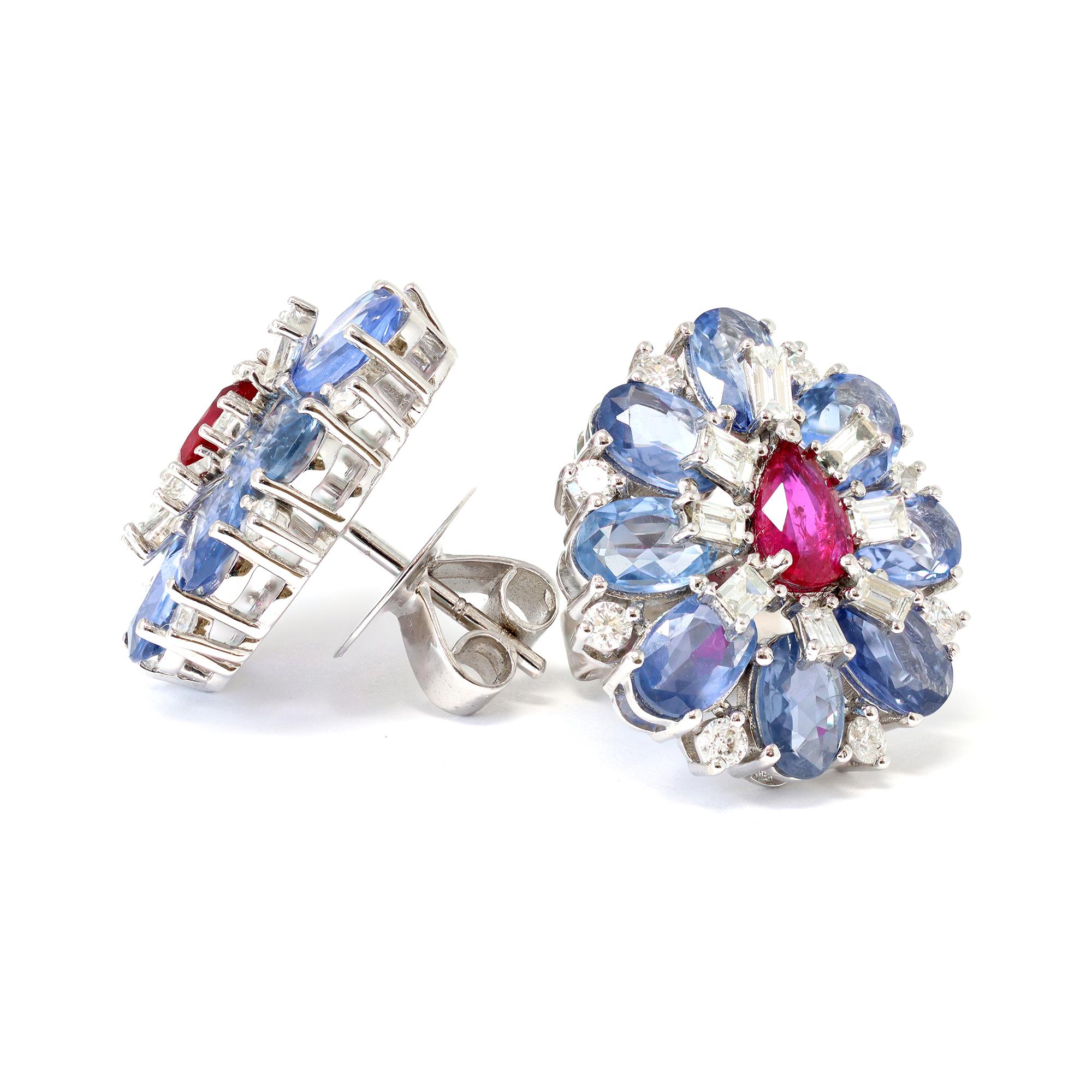 A Lovely cluster earrings Circa 1980-90, in the form of a pear shape design composed of blue sapphires, mixed cut diamonds, and a pear shape ruby in the center. The natural sapphires are very well matched, oval in shape, and displaying a lighter
