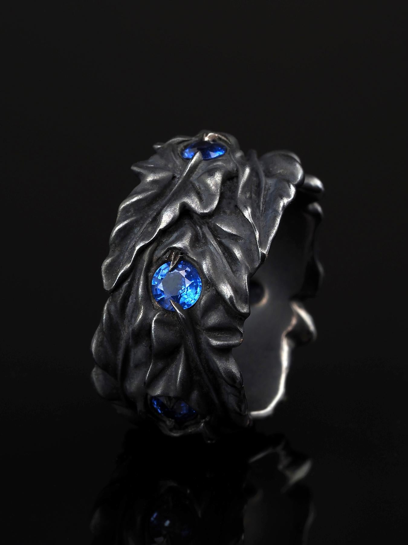 Bague en argent patiné noir en forme de feuilles de lierre avec saphirs bleus naturels de taille ronde. 
Origine du saphir - Sri Lanka
taille de l'anneau - 9.75
Poids de l'anneau - 17,5 grammes
Dimensions du saphir 0,16 x 0,16 in / 4 х 4 mm
Poids du