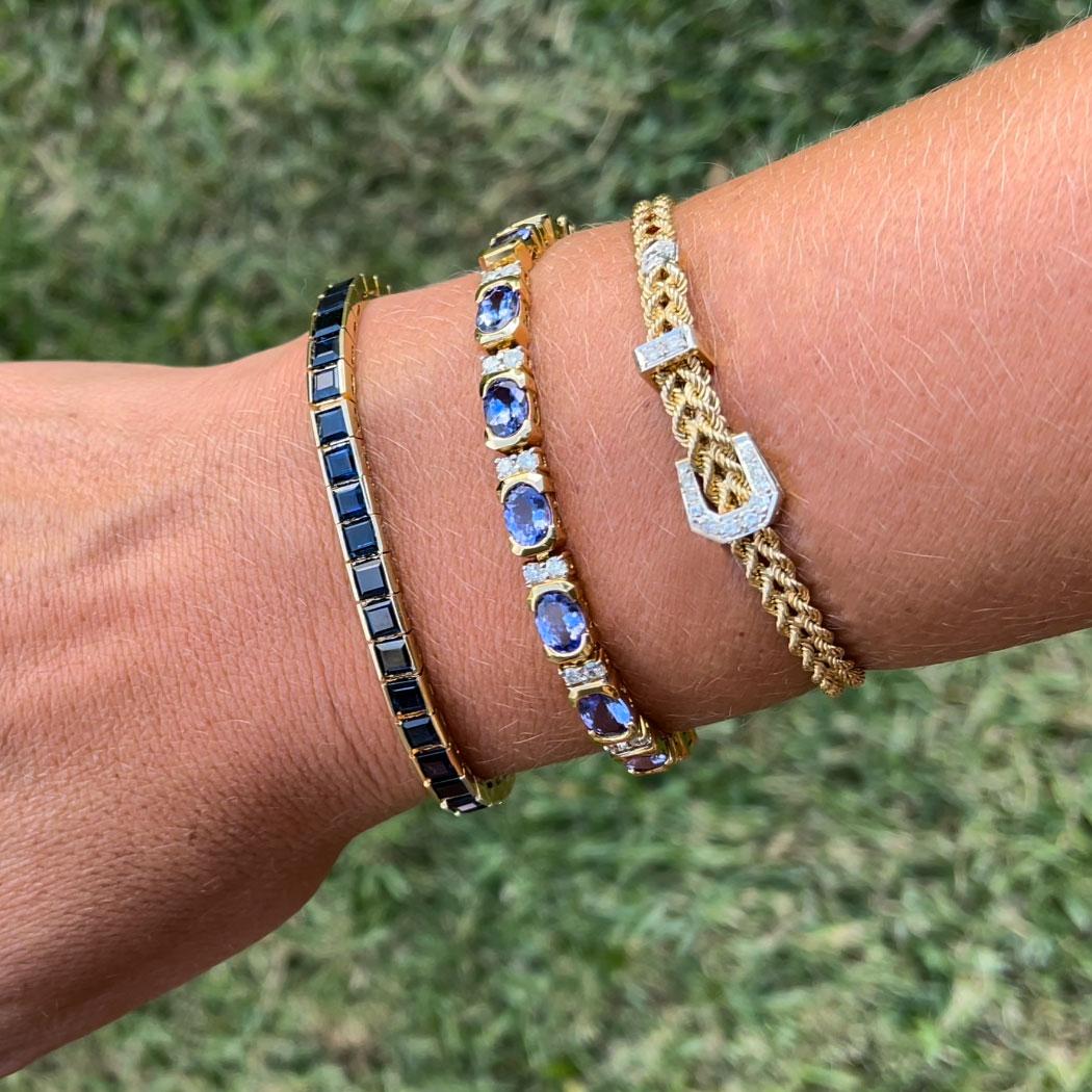 Tennisarmband mit blauem Saphir aus 14k Gelbgold. Dieses schöne Armband besteht aus 42 quadratischen blauen Saphiren im Stufenschliff. Jeder Saphir misst etwa 4,00 mm x 4,00 mm und hat insgesamt etwa 14,50 Karat. Die Saphire haben eine schöne