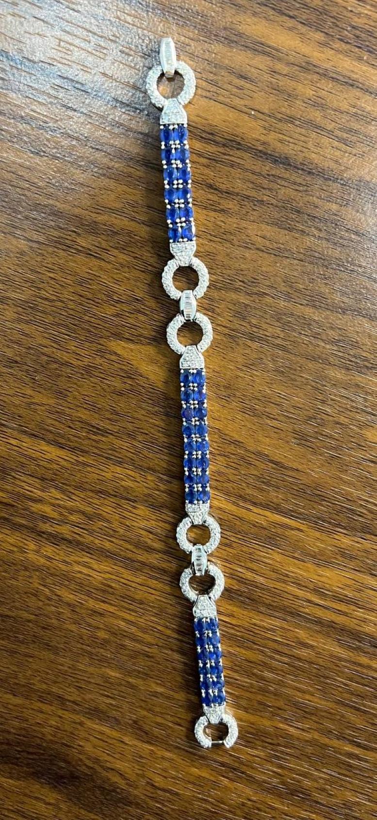Ce superbe bracelet présente une combinaison frappante de saphirs bleus et de diamants circulaires étincelants. Le bracelet présente une série de saphirs d'un bleu profond disposés de manière linéaire, entrecoupés de maillons ronds incrustés de