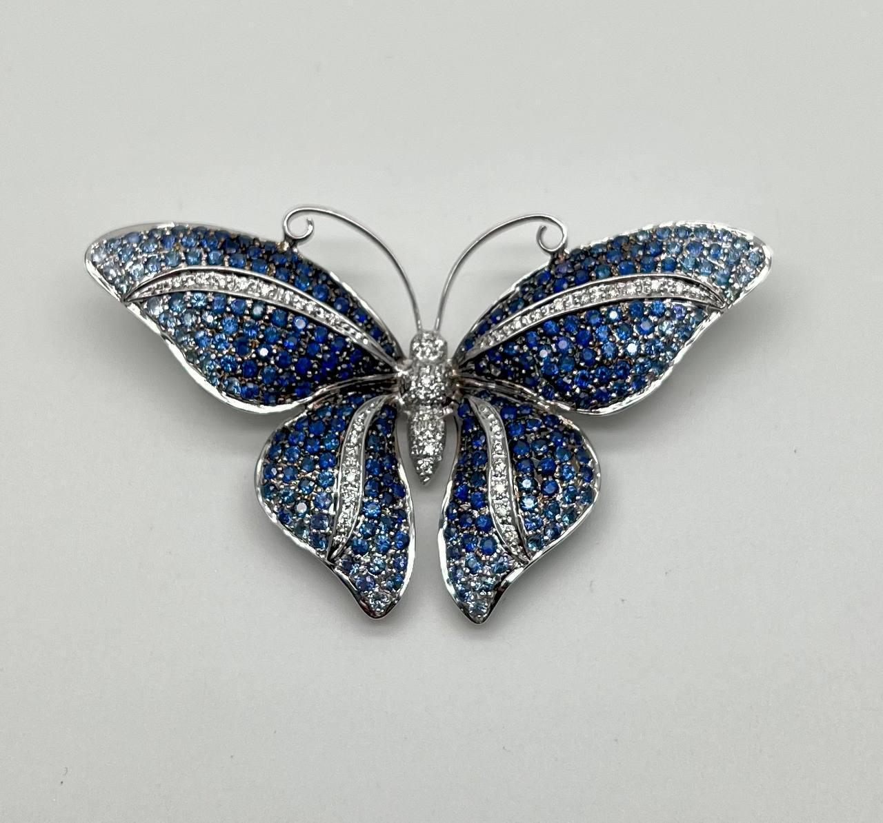 This exquisite butterfly brooch captivates with its intricate design and vibrant colors.

Crafted in white gold, it showcases a stunning array of blue sapphires and white diamonds, meticulously set to form the delicate wings. The upper wings are