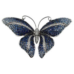 Alfiler broche de oro blanco de 18 quilates con zafiro azul y diamante blanco pavé mariposa