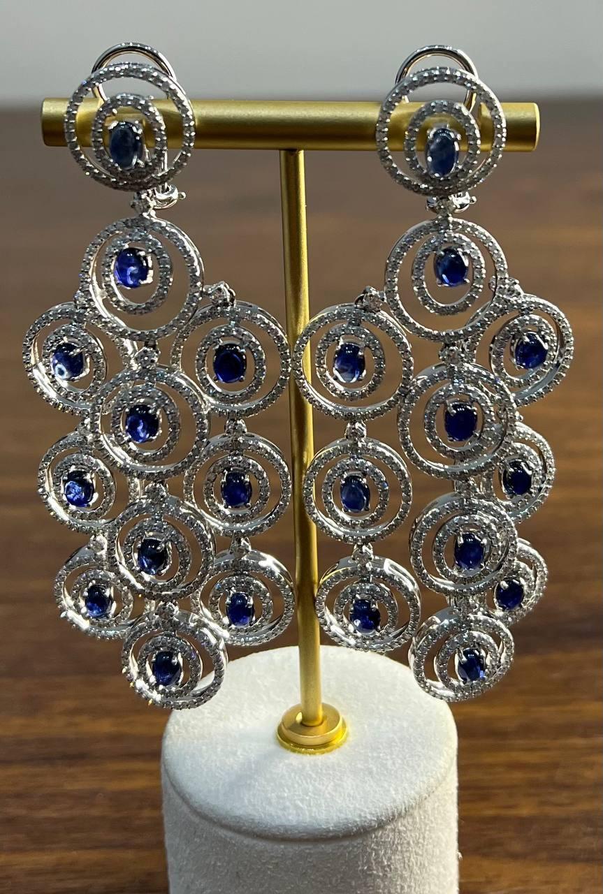 Elegant 21st Century Galt & Bro. Jewelers Earrings. These stunning earrings feature a cascading design with concentric circles adorned with vibrant blue stones. Each circle is encrusted with sparkling accents, creating a dazzling effect. The