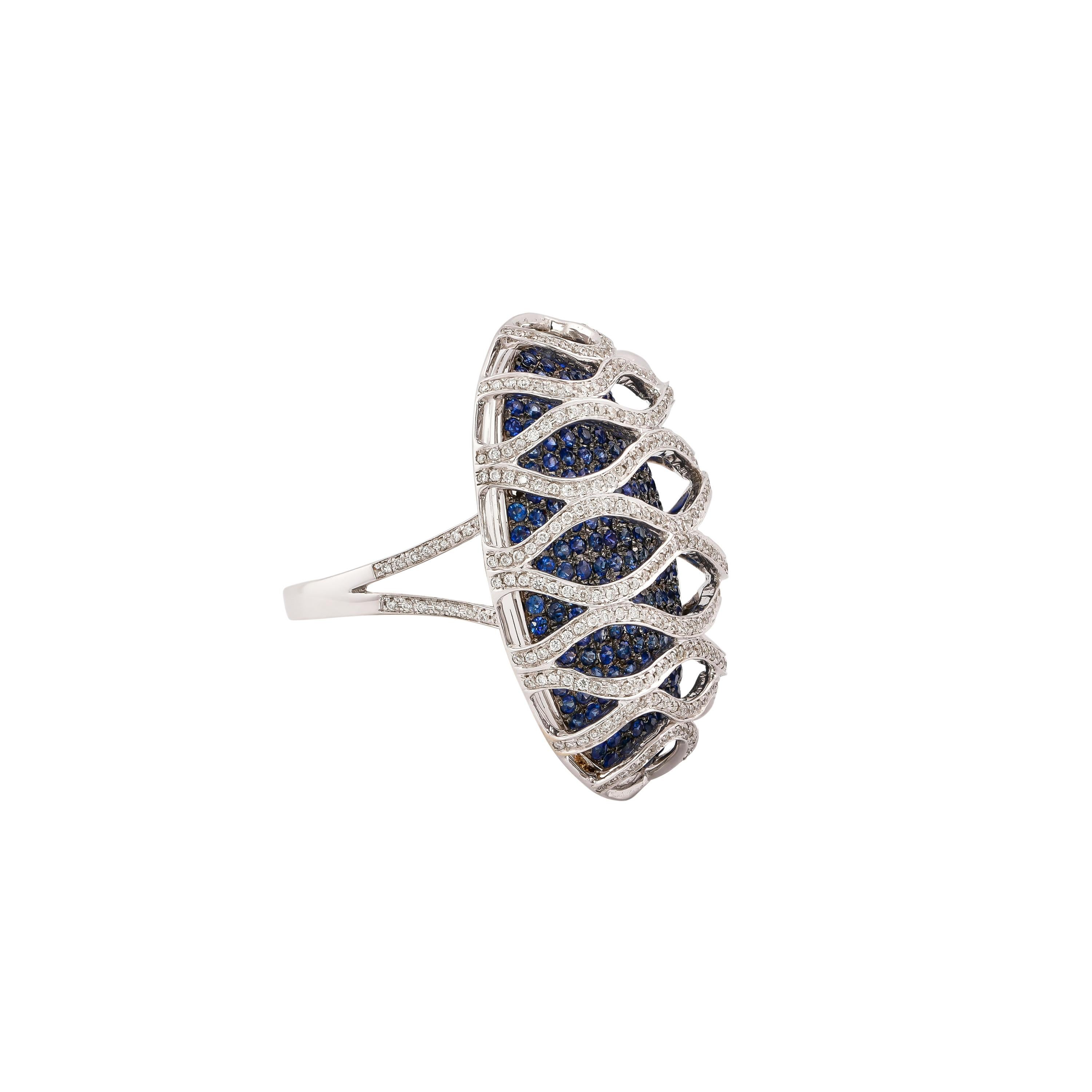 Sunita Nahata presents a collection of fancy cocktail rings with gorgeous gemstones. This ring uses a pave base of blue sapphire with an architecturally constructed diamond cage on top. This unique and contrasting design presents a striking cocktail