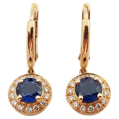Boucles d'oreilles en or rose 18 carats serties d'un saphir bleu et d'un halo de diamants