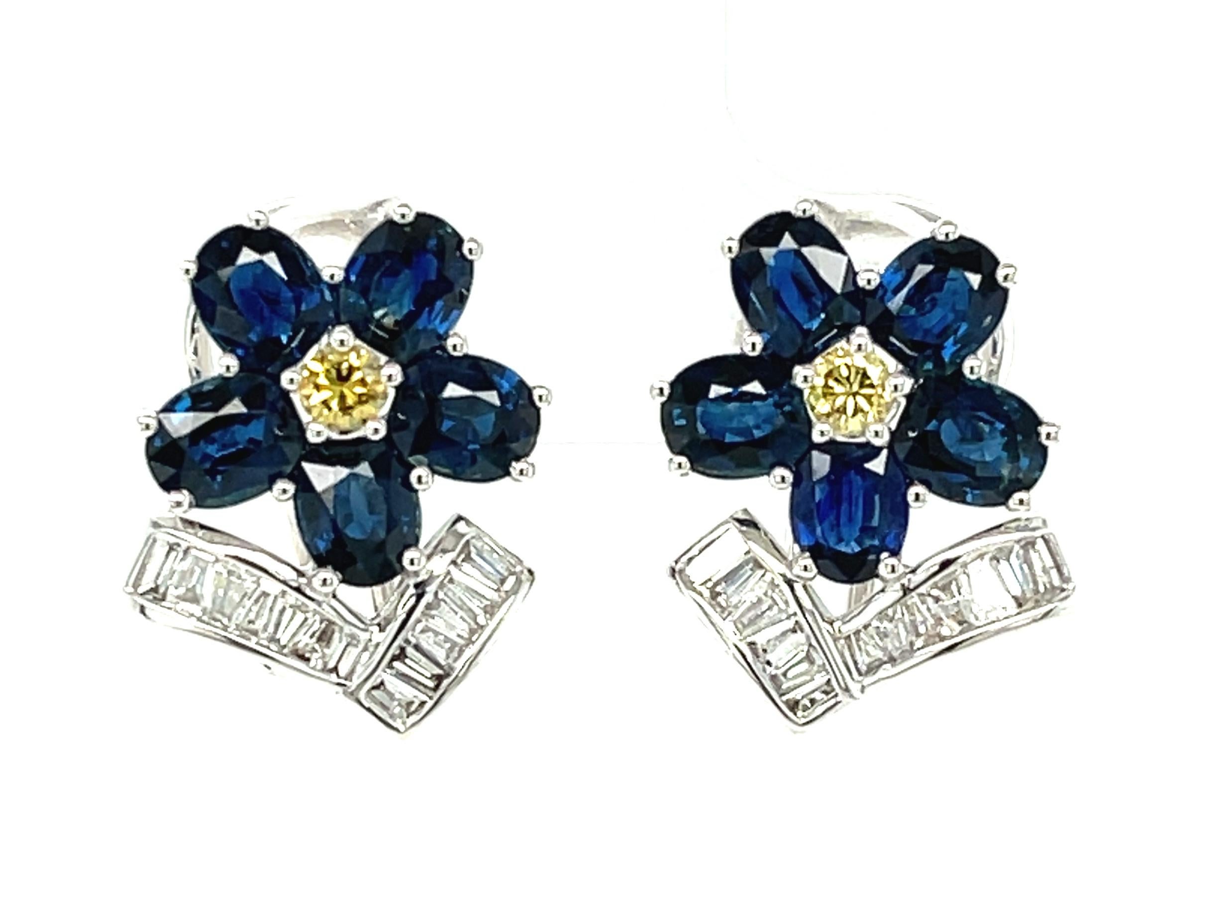 These beautiful earrings feature over 4 and a half carats of rich, royal blue sapphires, set in an exquisite floral design with with 2 brilliant cut yellow diamonds in the center of each 