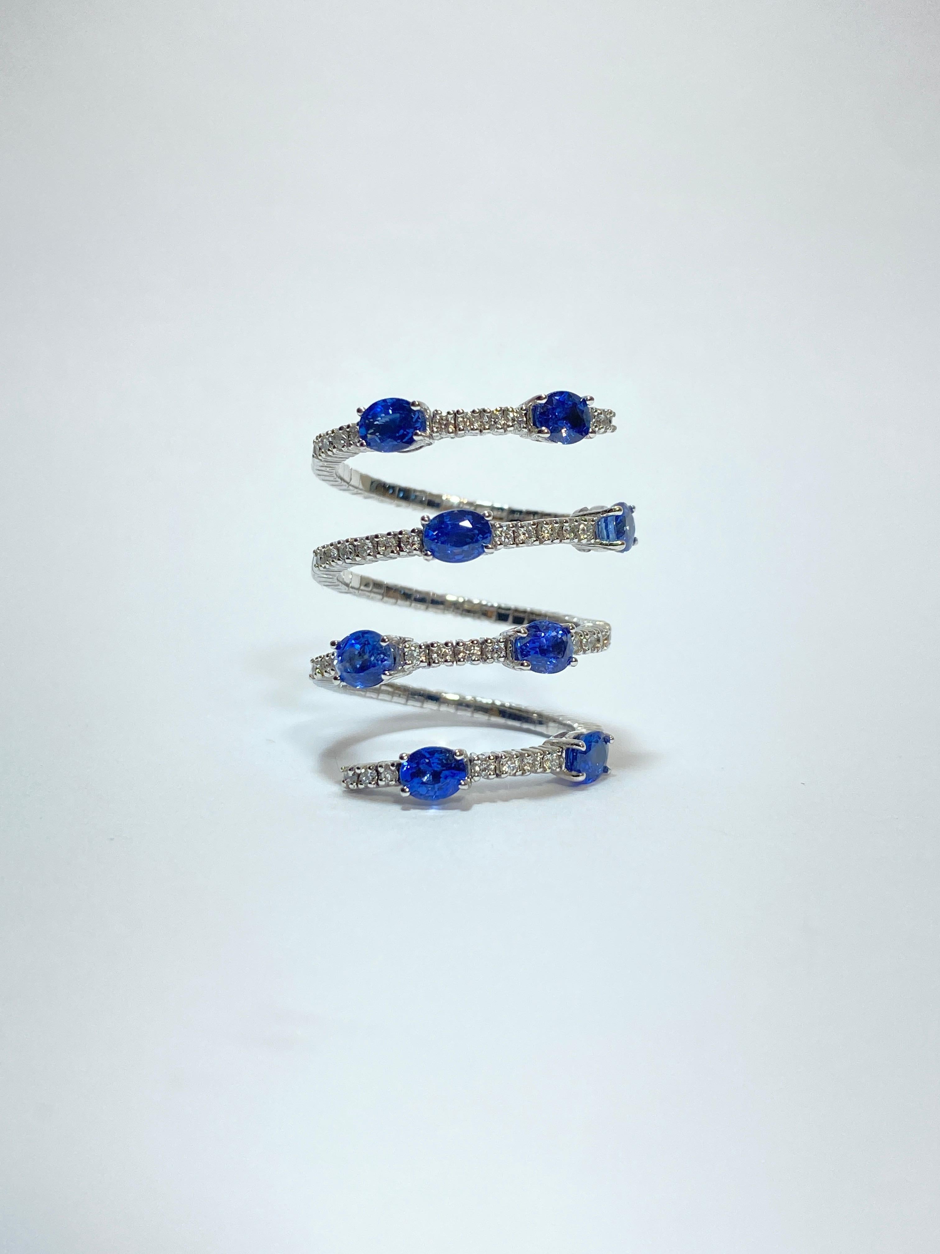 Jewel inspired by the sinuous movements of the snake.
This ring has an elastic structure made in 18 Kt white gold ( gr.6.20 ) and it's embellished with four rows of white diamonds (ct 0.49) and eight oval cut blue Sapphires  (ct 2.42) to create an
