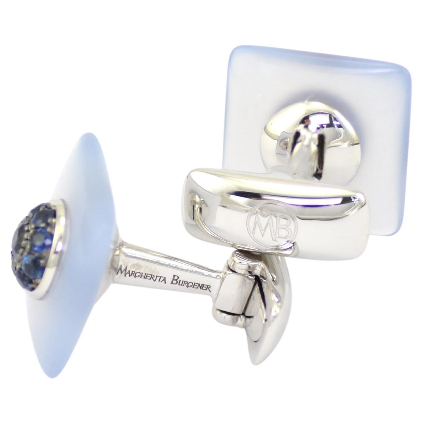 Designed and handcrafted in Margherita Burgener workshop, the refined cufflinks are realized in white gold set with blue sapphires. The light blue stone, squared shaped, slightly bombé, is natural chalcedony. It is a unisex piece of jewelry.
They