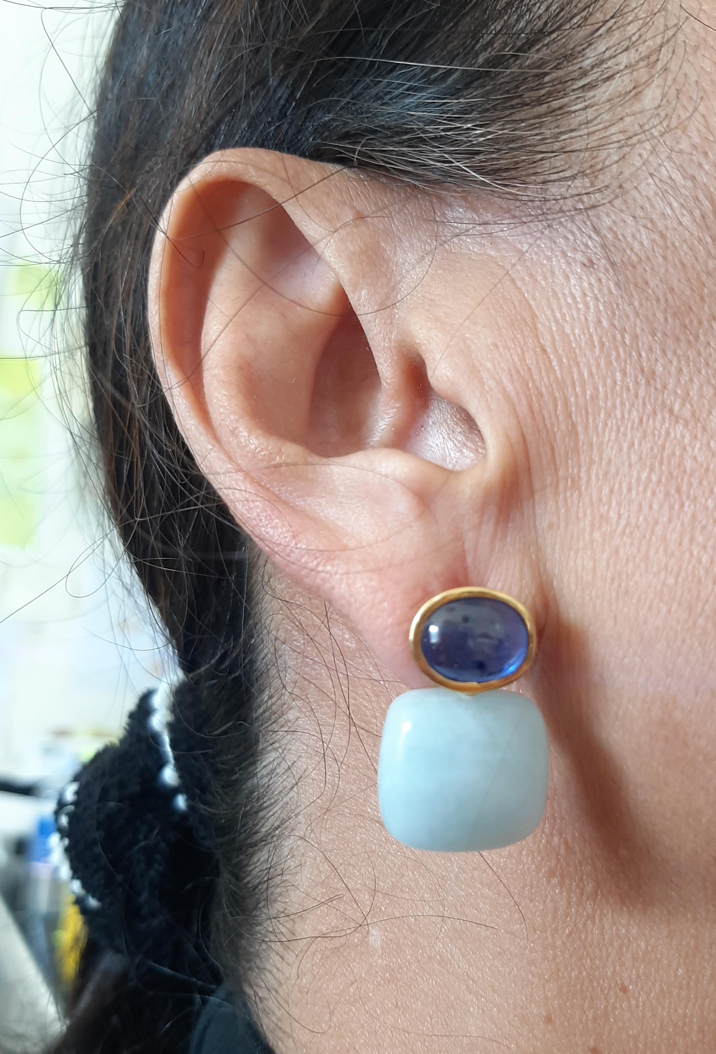 These simple but elegant and handmade earrings have 2  Blue Sapphires Cabs measuring 8 x 10 mm set in a 14 Kt solid yellow gold bezel at the top to which are suspended 2 Aquamarine Cushion Shape Cabs measuring 137x 17 mm.

In 1978 our workshop
