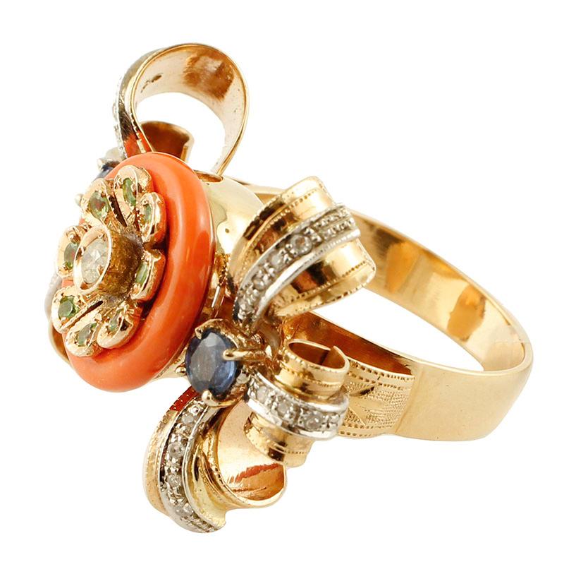 Gorgeous cocktail ring in 14 kt rose and white gold structure mounted with a coral ring and a gold flower in the central part and, on the sides, it is adorned with blue sapphires and two rose and white gold bows studded with little diamonds.
This