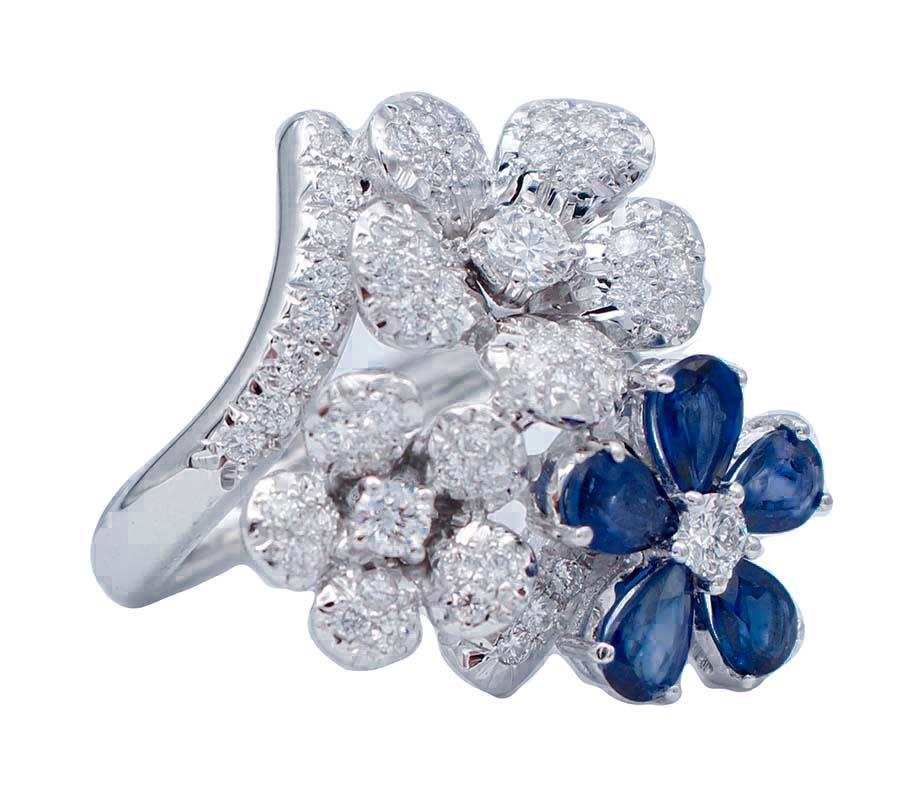 Amazing modern ring in 18 karat white gold structure mounted with a flower of blue sapphires with a central diamond and two flowers of diamonds.
Diamonds 1.57 ct
Blue Sapphire 2.78 ct
Total Weight 10.70 gr
RF  +EEAR
Italian Size 15
Usa Size