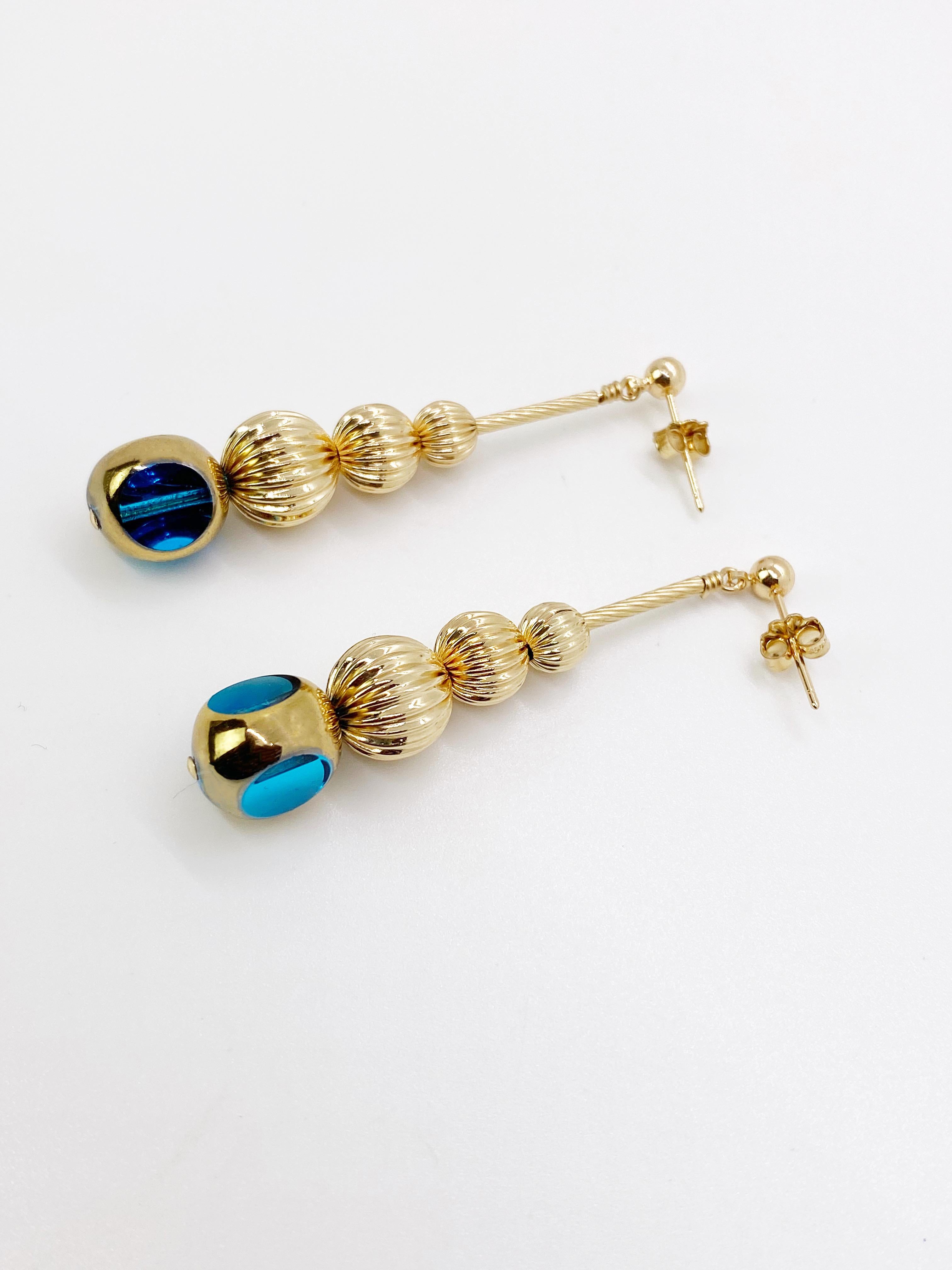This is a listing of a pair of earrings. Each earring consist of 1 semi-round translucent blue German vintage glass beads that are first plated with platinum and then plated with 24K gold. They are complimented with 3 graduated corrugated round