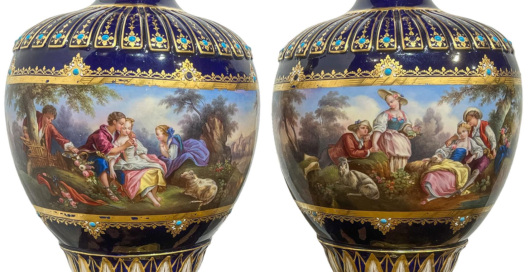 Blue Serves Pair of Jeweled Vases with Gilt Paint and Turquoise embellishments throughout. Incredibly ornate with gold painted details throughout. Both vases contain genre  scenes with focal points of figure groups relaxing in the forrest with lush