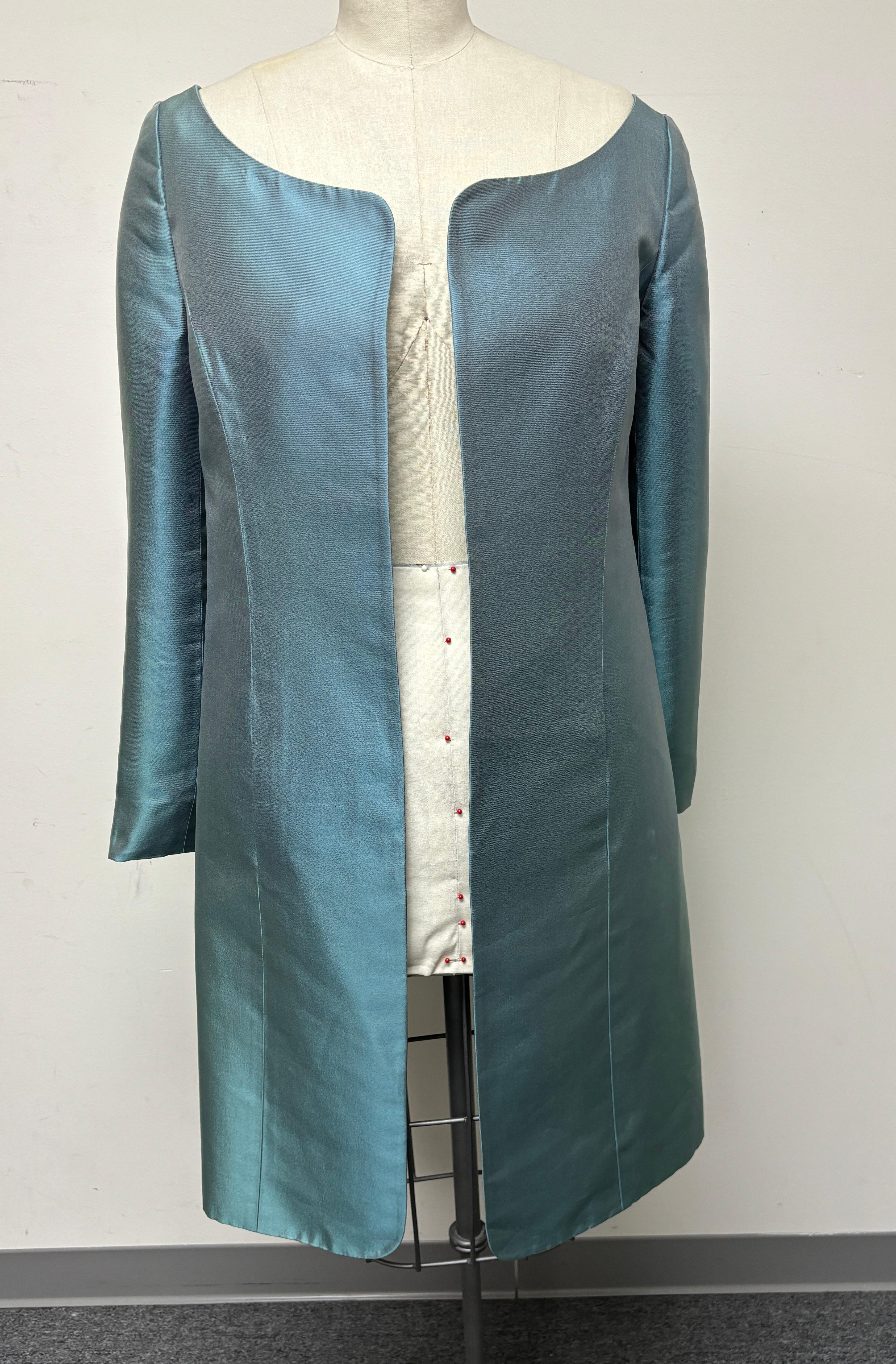 The perfect silk overcoat that can be worn over a dress, pants, or evening gown. Shaped neckline with pleat-back detail. The most beautiful shade of aqua. The finest silk from Teroni in Italy. A timeless classic, a great addition to your wardrobe. 