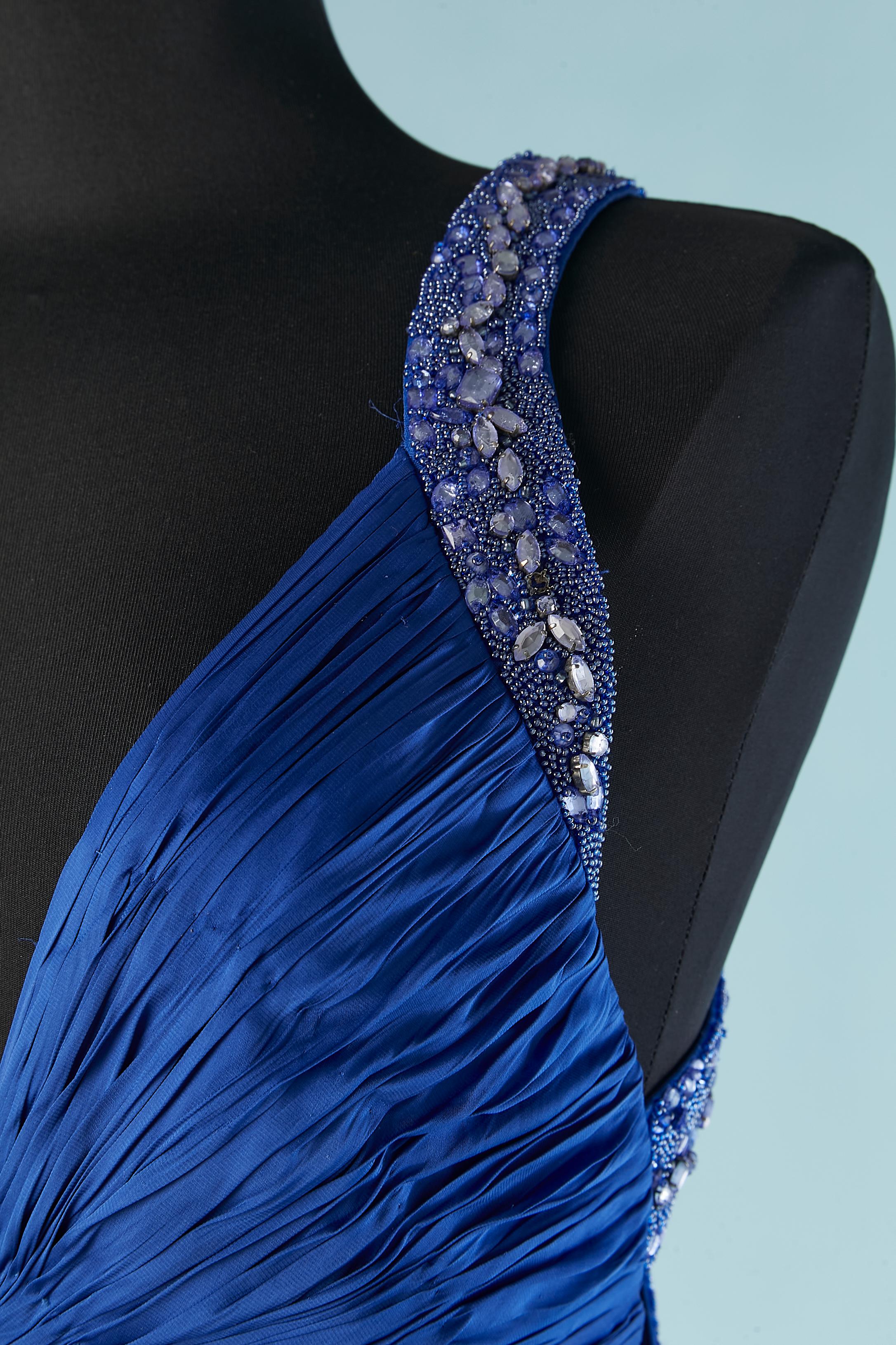 Vestido de noche plisado de seda azul con efecto arrugado y pedrería.
Más largo por detrás. Ojal y corchete en el lado izquierdo y cremallera en el centro de la espalda. Holograma de autenticidad . Dividida en la parte delantera central (longitud =