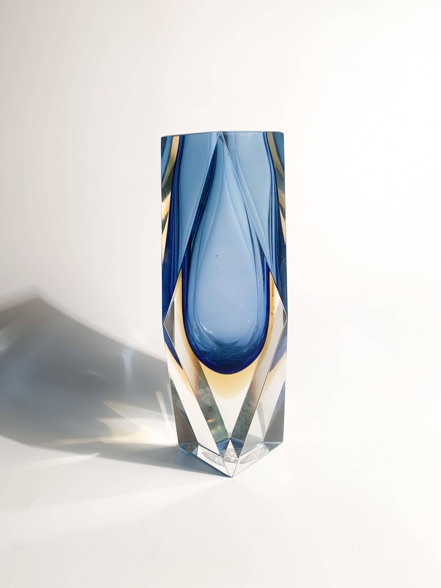 Single-flower vase in blue Murano glass made with the submerged glass technique. The shape is geometric and the realization is attributed to Flavio Poli in the 70s.

The vase has very light chip as illustrated in the photos. Further photos on