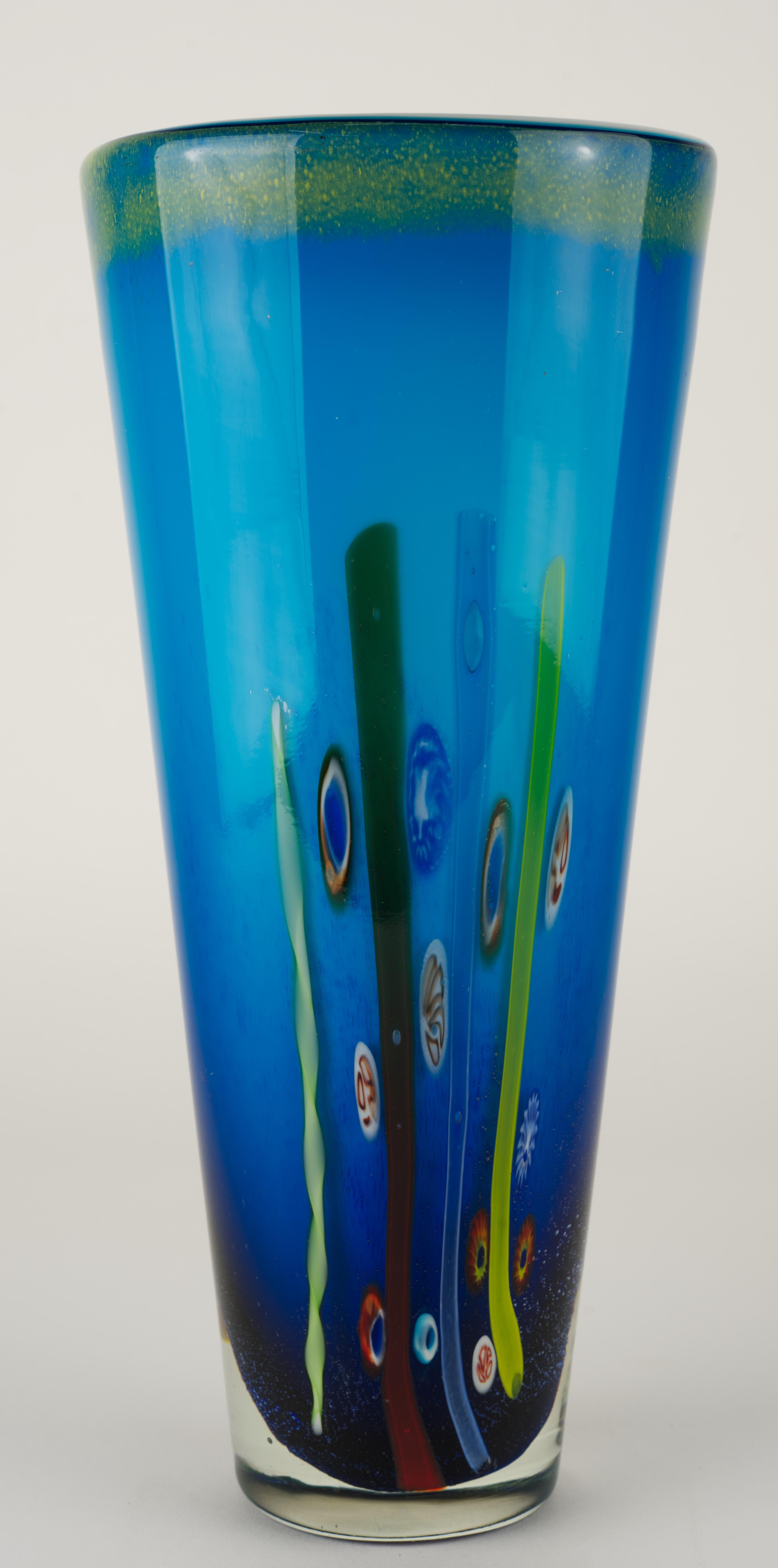  Jarrón vintage de cristal de Murano realizado con la técnica del sommerso, con piezas de cristal blanco macizo revestidas de cristal azul ombre e inserciones de murina fundida revestidas de cristal transparente. 

El jarrón está hecho al estilo de