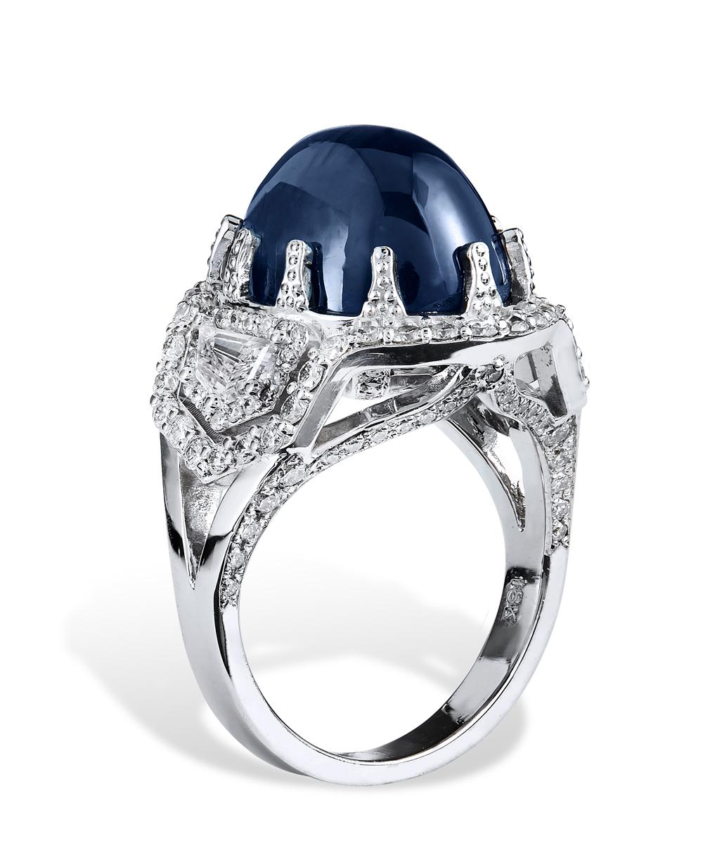 Custom CAD designed gem blue star sapphire ring with center star sapphire stone approx. 16.56 CTS set in 18k white gold with approx. 1.57 CTS of diamonds F-G color and VS clarity. This one of a kind ring has two flanking cadillac shaped diamonds on