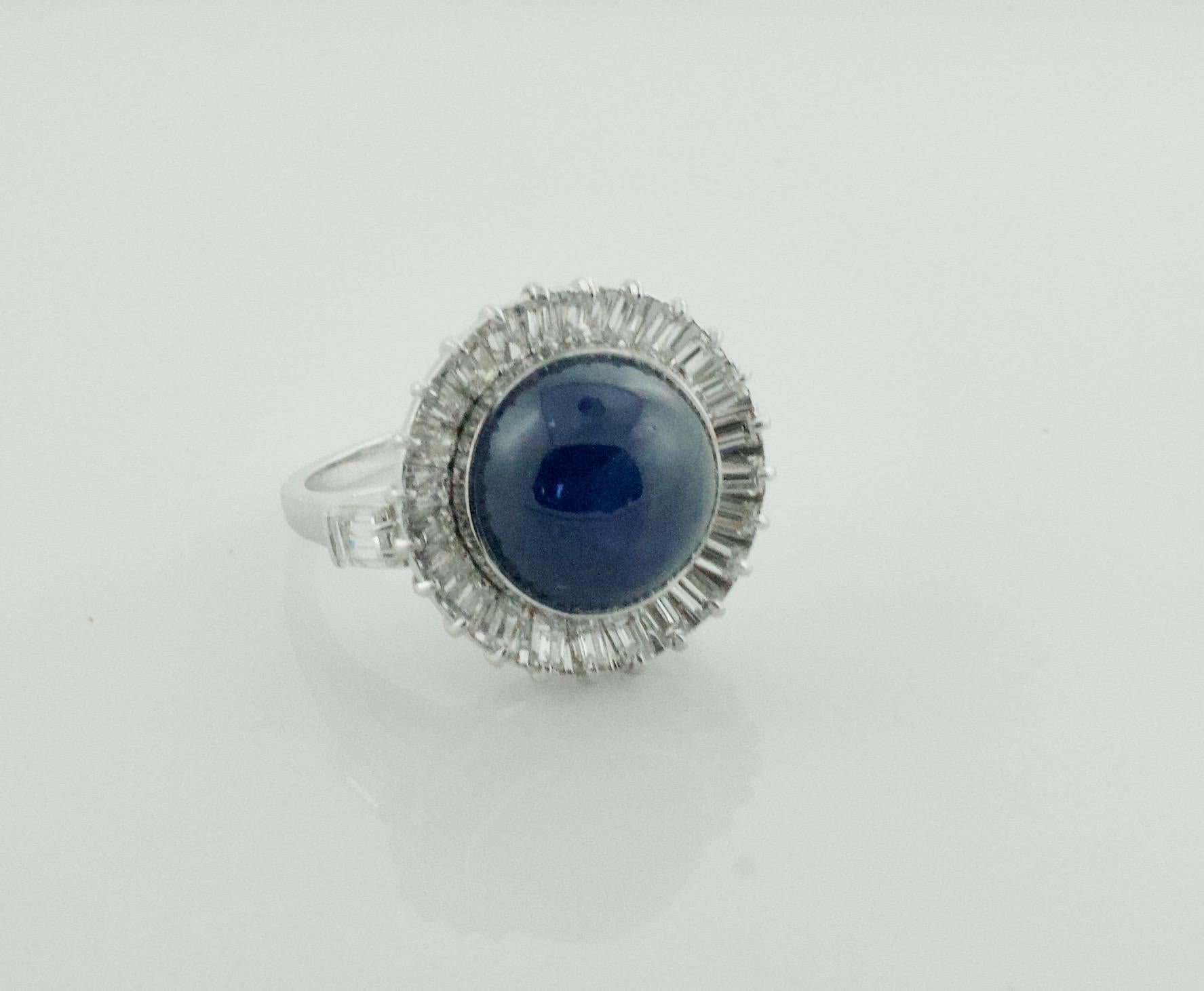 Blue Star Sapphire and Diamond Ring in Platinum circa 1950's
A Rare Deep Blue Round Cabochon Weighing 11.75 Carats Approximately. Very Nice Star Which is Rare in The Deep Blue Stars. 
27 Baguette Cut Diamonds Weighing 1.50 Carats Approximately [GH