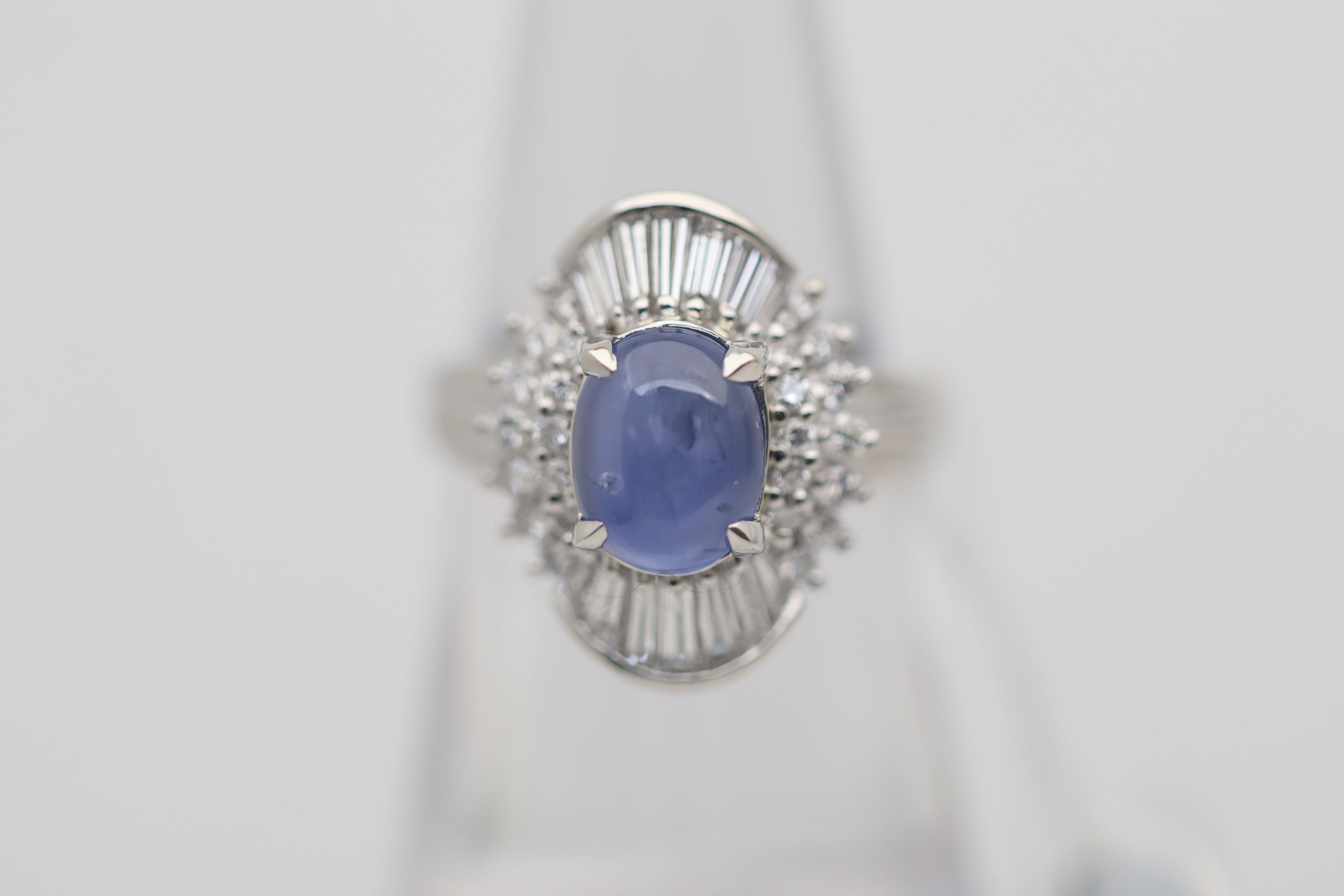 A beautiful 3.47 carat star sapphire takes center stage. It has a clean open blue color along with a 6-rayed star when a light hits the top of the stone. It is complemented by 0.90 carats of round brilliant and baguette-cut diamonds set around the