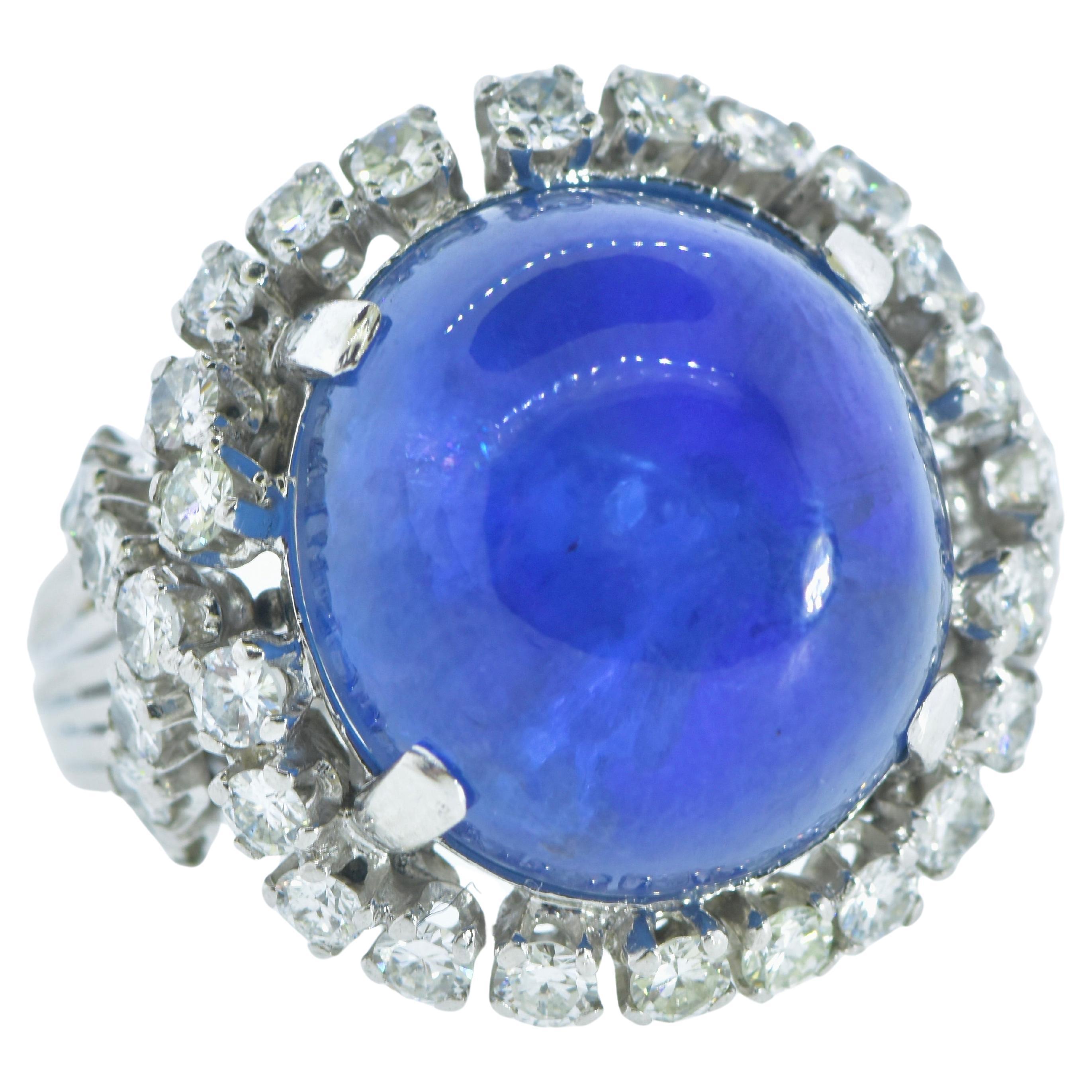 Star sapphire, unheated,  weighing an estimated 15 cts by our internal gemologist, this stone is large and impressive displaying a medium blue/violet color.   Accenting this center stone are 36 white brilliant cut diamonds, well matched in their