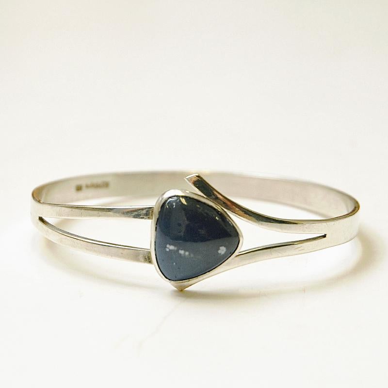 Bellissimo bracciale in argento con pietra Bergslag blu di Victor Jansson per Lindesberg, Svezia 1966. La pietra ha una forma triangolare e tracce di pietra bianca al suo interno. Chiusura interna per aprire e chiudere. All'interno è contrassegnato