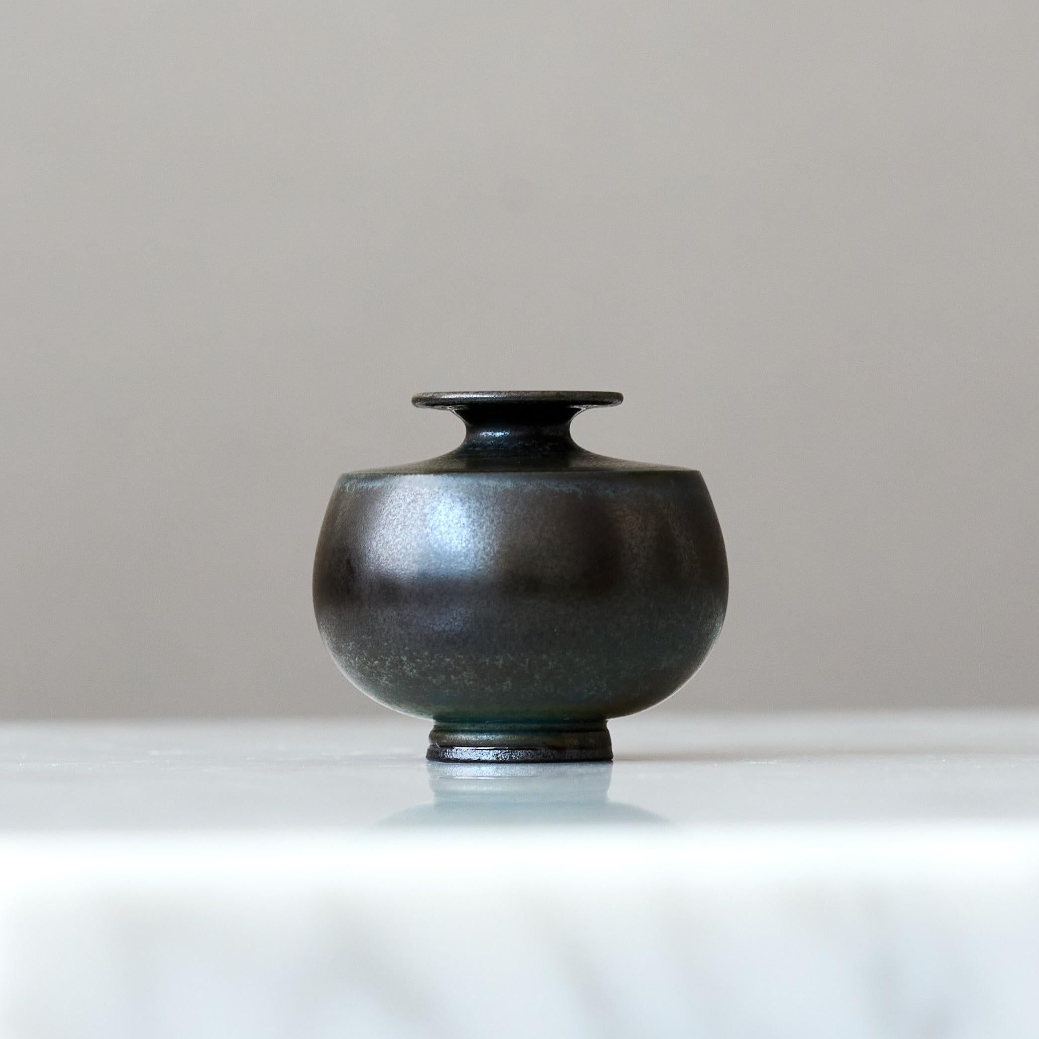 Un bellissimo vaso in gres in miniatura con un'incredibile smaltatura a pelo di lepre blu-verde scuro.
Realizzato dal maestro lanciatore Berndt Friberg, nello studio dell'artista a Gustavsberg, Svezia, negli anni '60.

Ottime condizioni. 
Firma