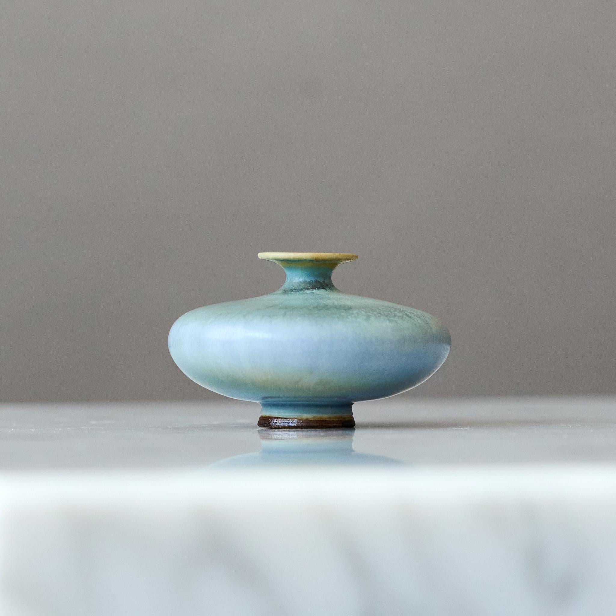 Precioso jarrón de gres en miniatura con un sorprendente esmalte de pelo de liebre azul claro.
Realizado por el maestro lanzador Berndt Friberg, en el estudio del artista en Gustavsberg, Suecia, década de 1960.

Gran condición. 
Firma incisa